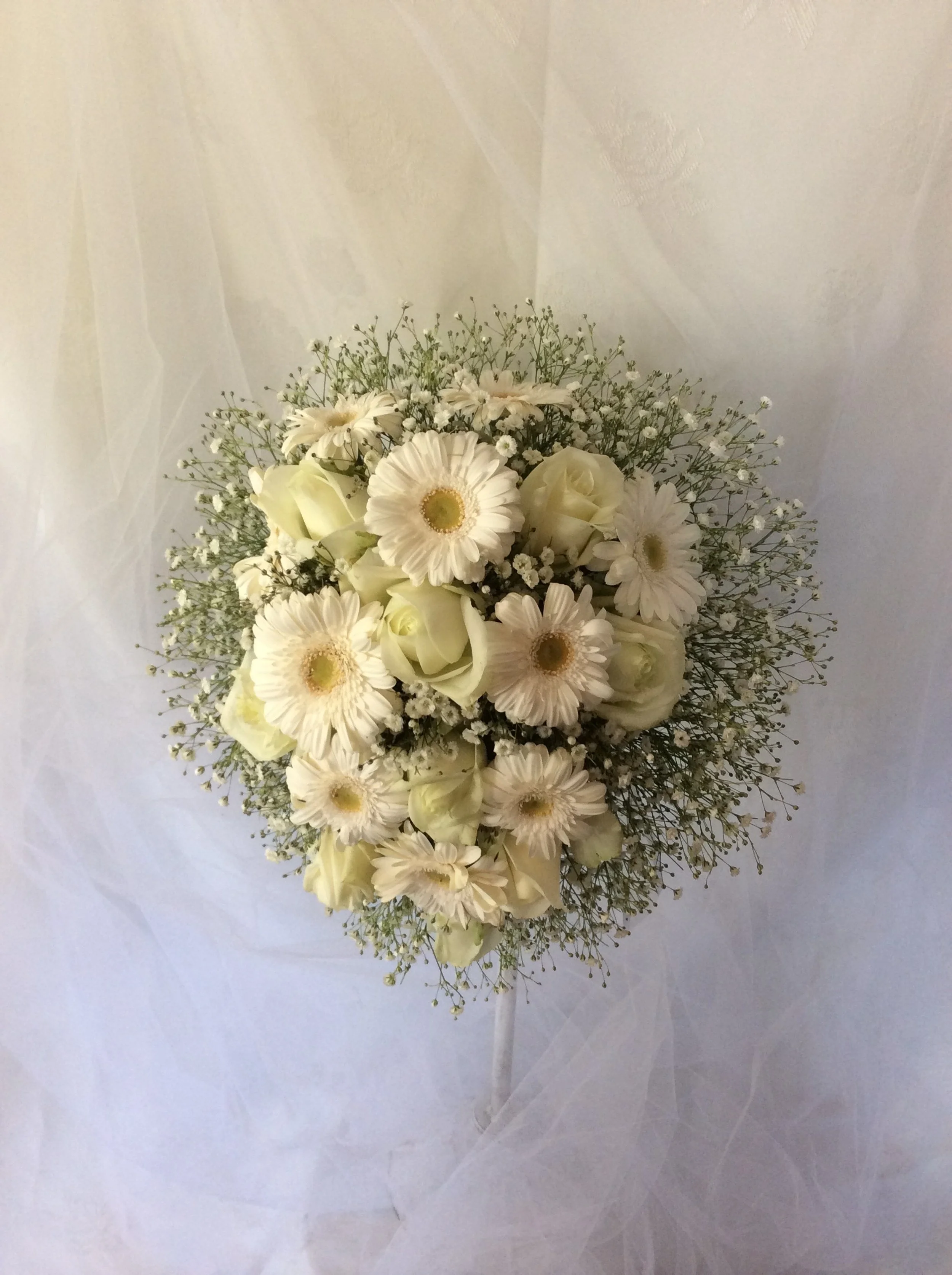 15年以上ブーケショーを名古屋で行ってきたMASAKO MODESTE（マサコモデスト）のウエディングブーケ。ガーベラとかすみ草をふんだんに使用した、可憐で上品なラウンドスタイルのフラワーデザイン。