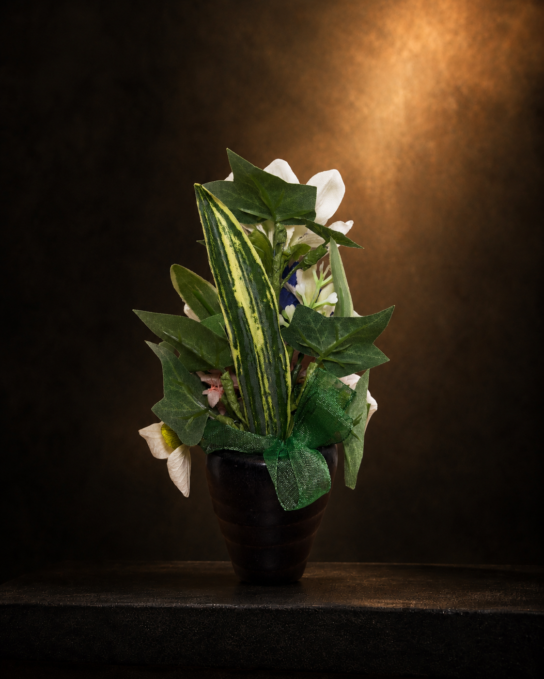 イノリユイの仏花「souka（想花）」を背面から撮影した商品画像。黒い花器にグリーンの葉とリボン、白い花を合わせ、背面まで丁寧に仕上げたマサコモデストの高級感あるアーティフィシャルフラワー供養花。