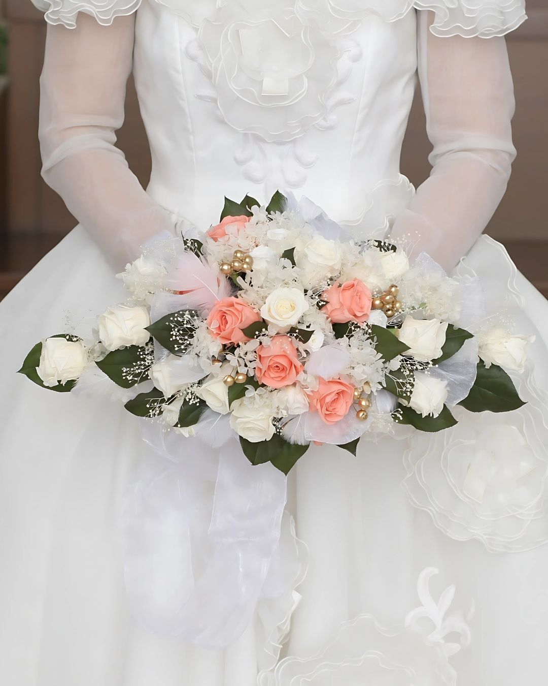 白いドレスを着た女性がピンクと白の花束を持っている