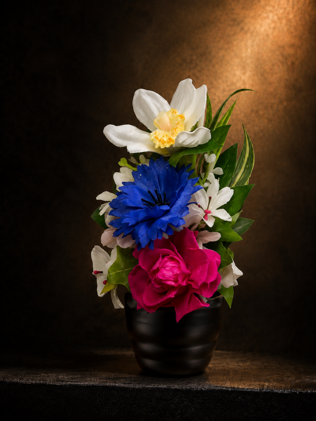 イノリユイの仏花「souka（想花）」を右斜め60度から撮影した商品画像。白・青・濃いピンクの花々を黒い花器に上品に合わせた、マサコモデストの高級感あるアーティフィシャルフラワーの供養花。