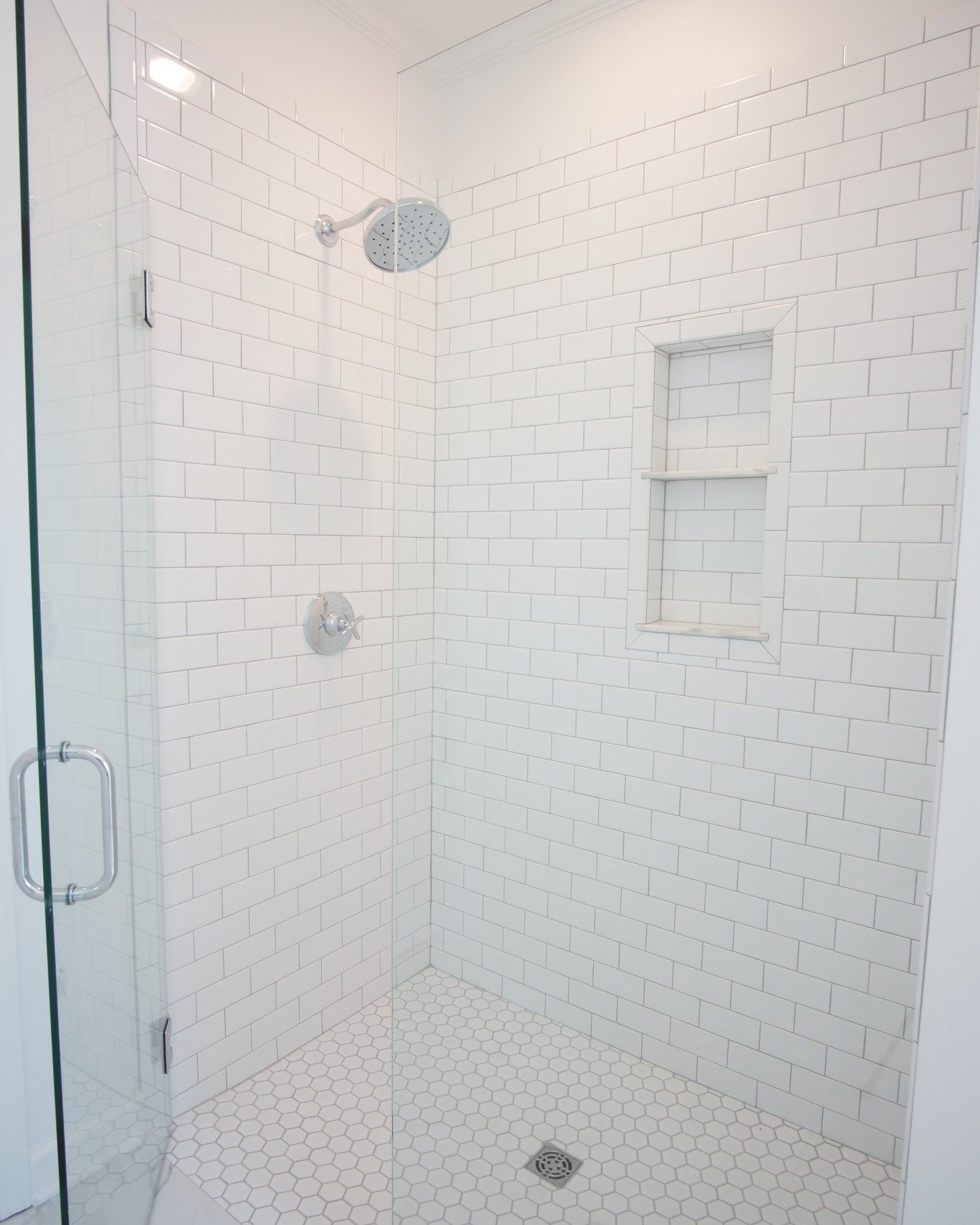 The master shower and kitchen at 1698 Harper Joy.  Classic finishes of subway tile and hickory wood floors.
