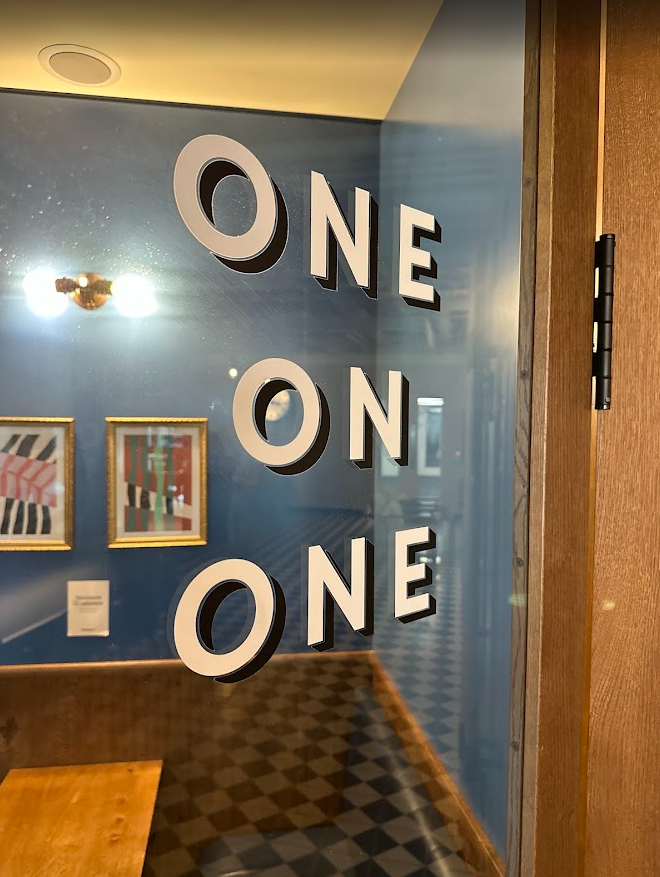 Door marked 'one on one' with a blue wall and abstract artwork in the background.