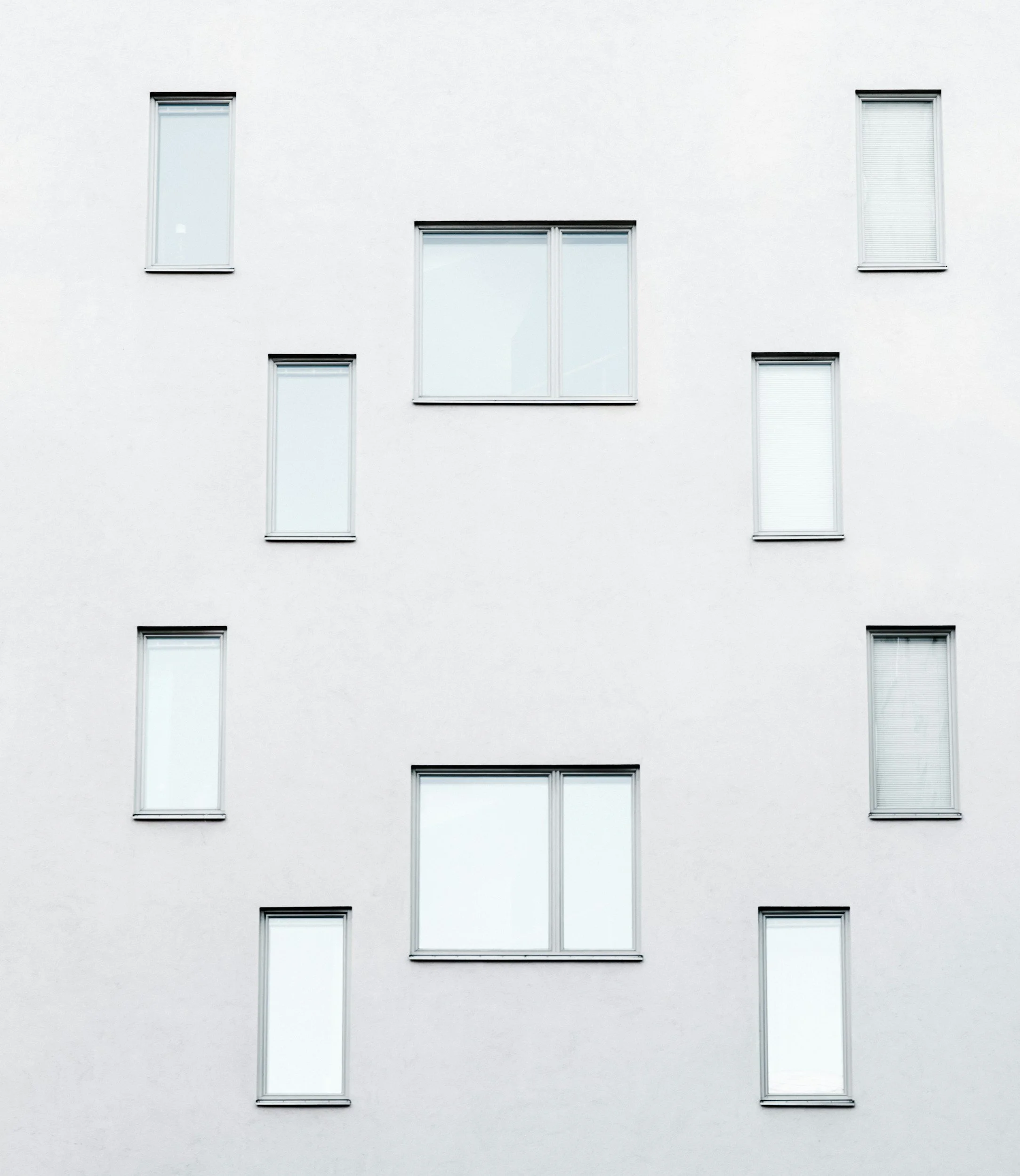 Fasad av en vit byggnad med åtta fönster.