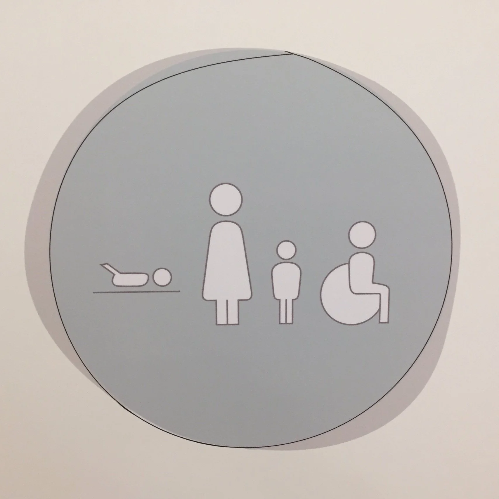 Hinweisschild mit Symbolen für Babywickelstation, weibliche, männliche, kindliche und rollstuhlfahrende Personen.