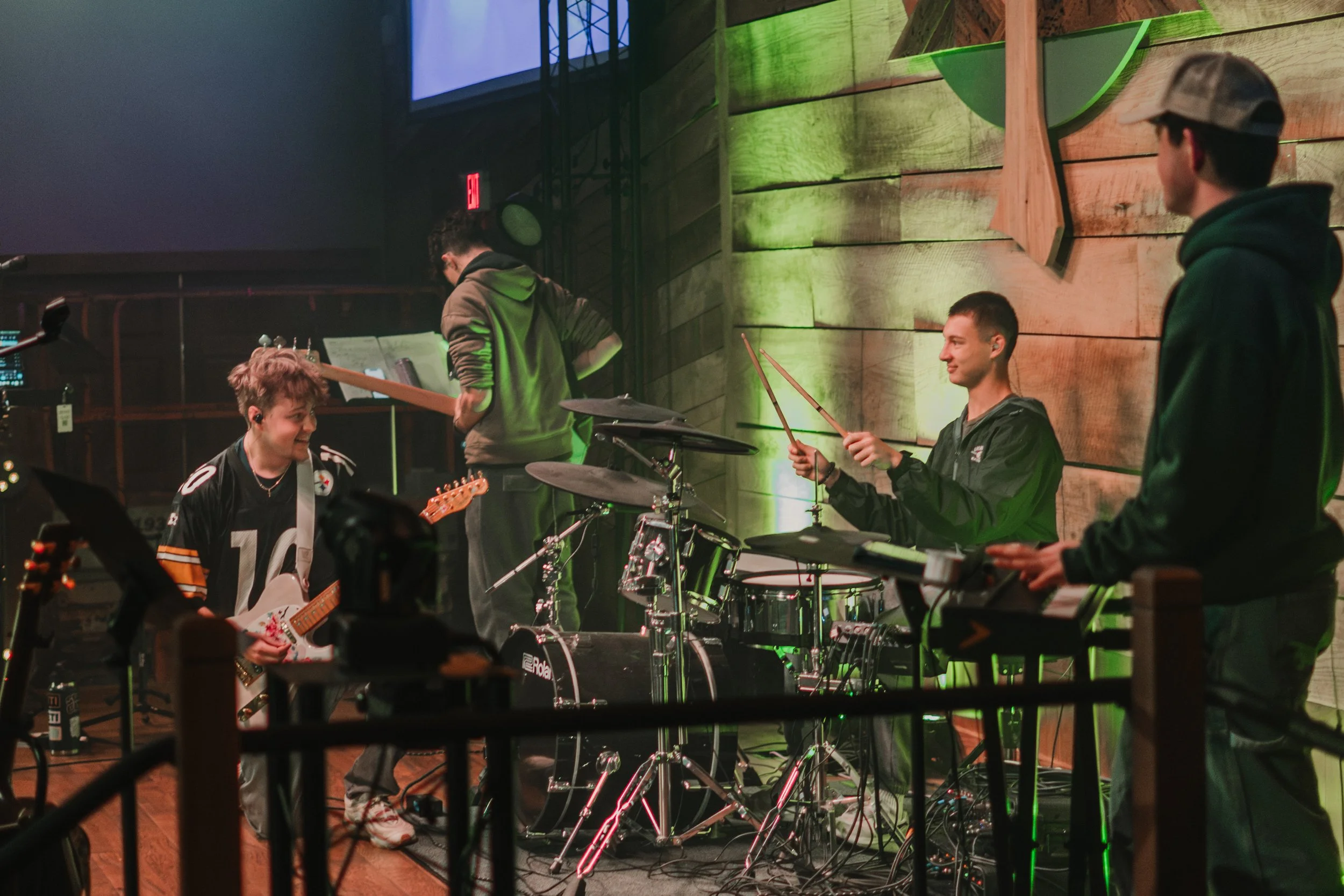 A group of four young musicians playing instruments on a stage