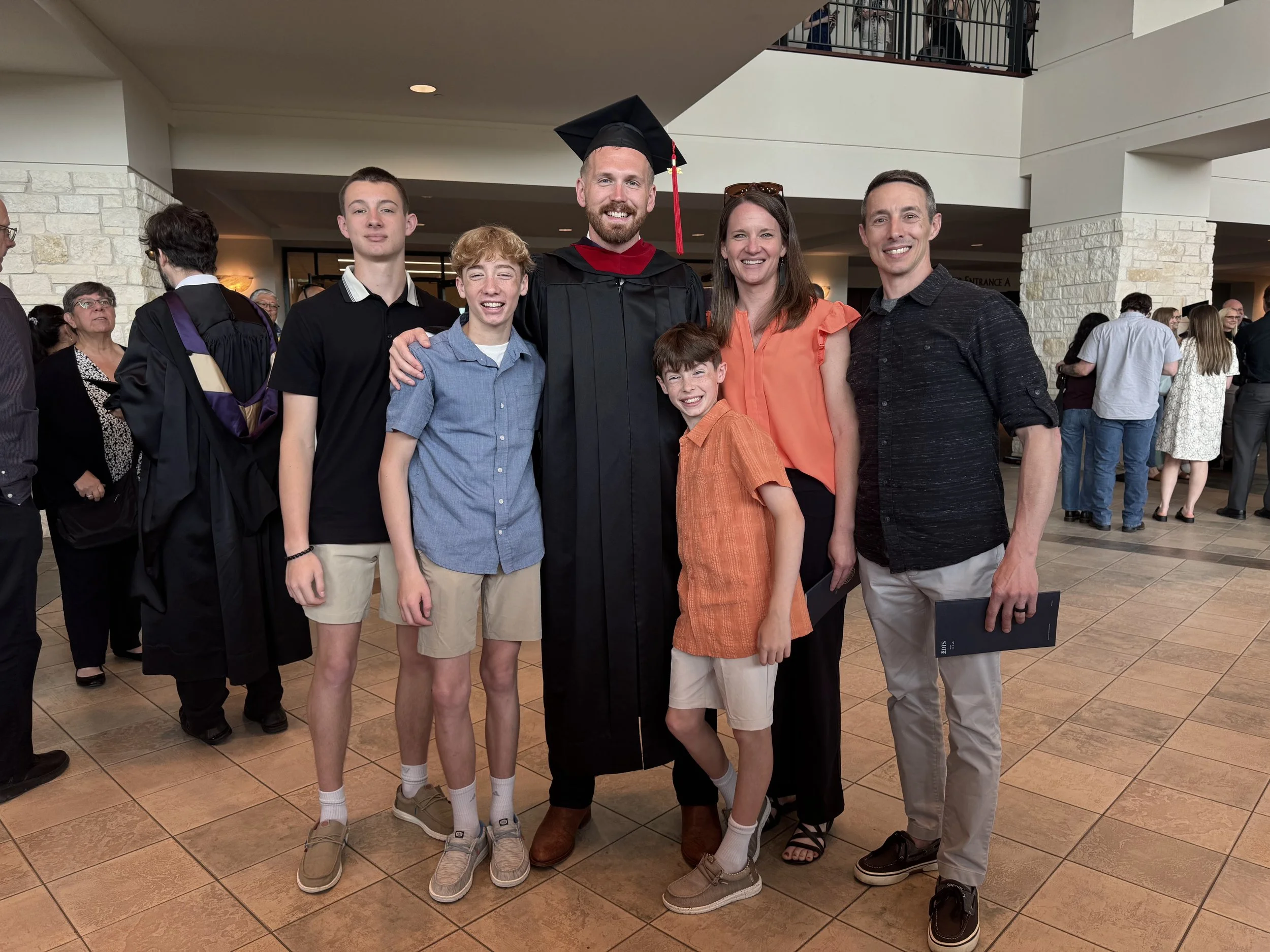 Group of family and friends posing together at a graduation ceremony