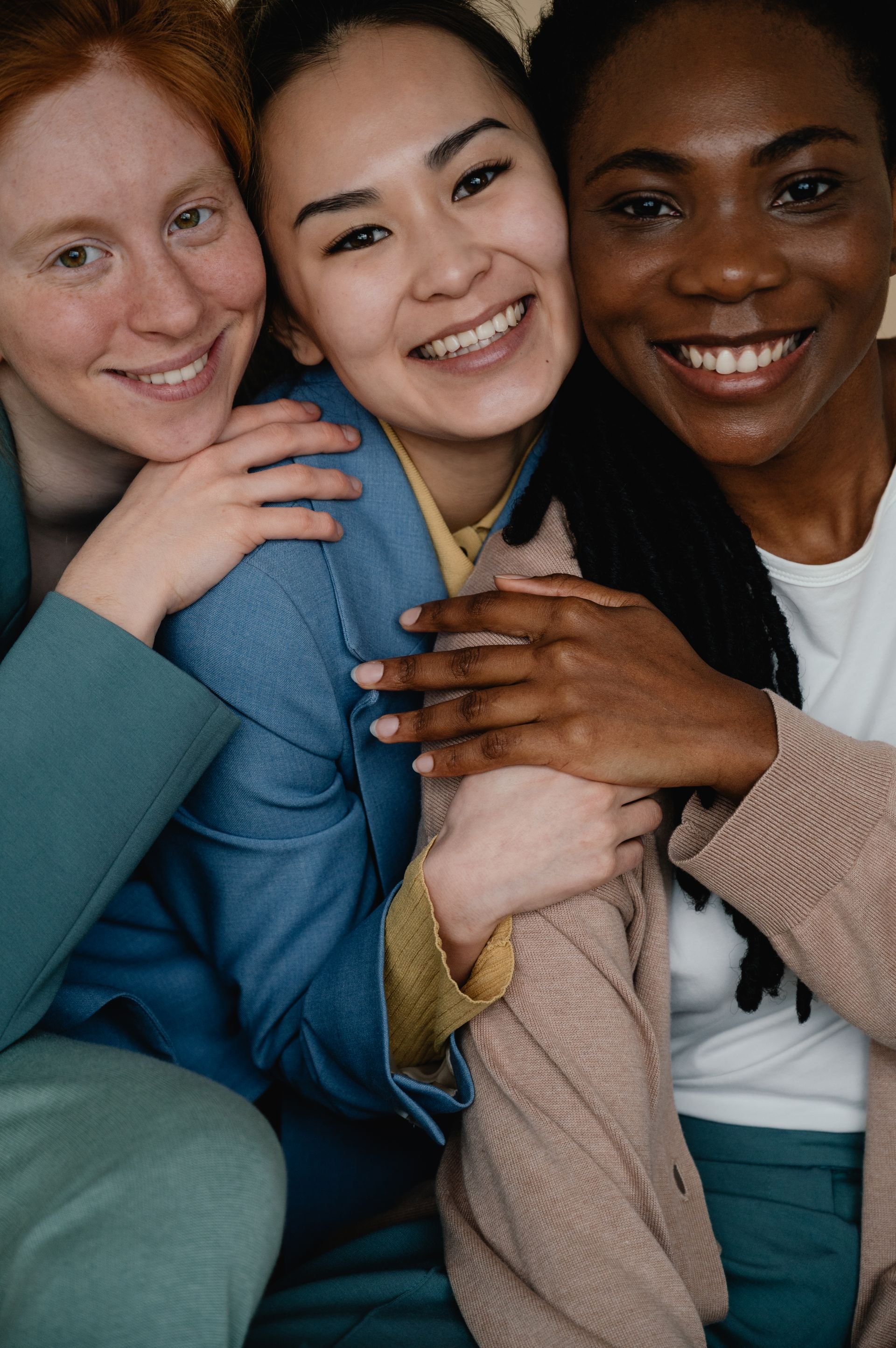 Three resilient, high-performing professionals smiling, illustrating the activated Bioful state and internal physical capacity framework by WellThera.