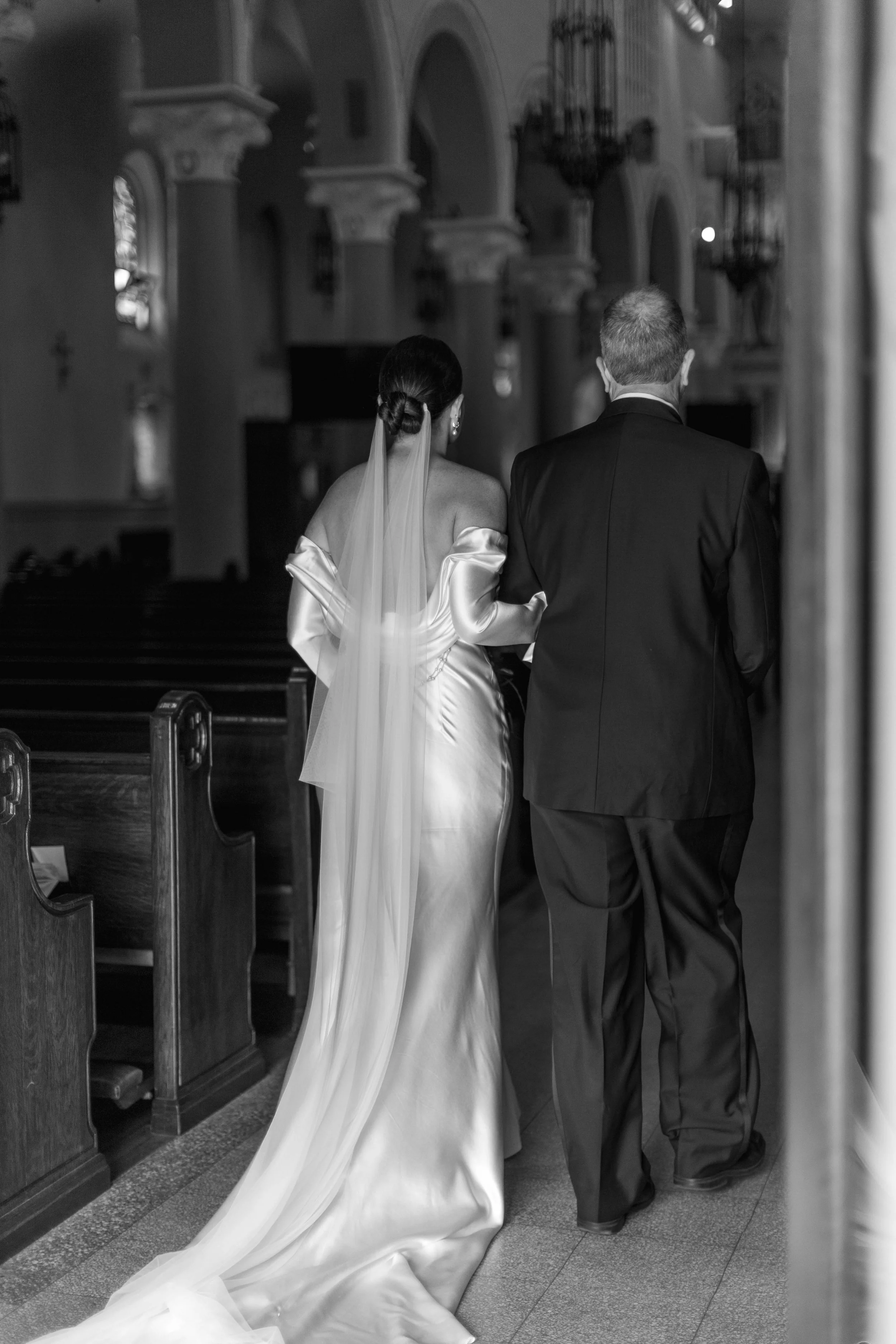 Bride being walked down the aisle by her dad in a catholic cathedral in Los Angeles California