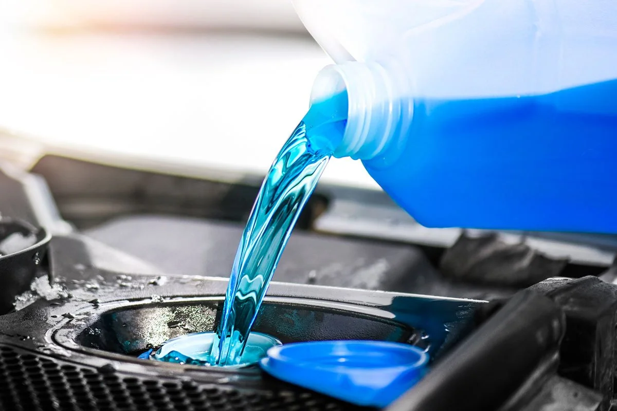 Blue fluid poured into vehicle