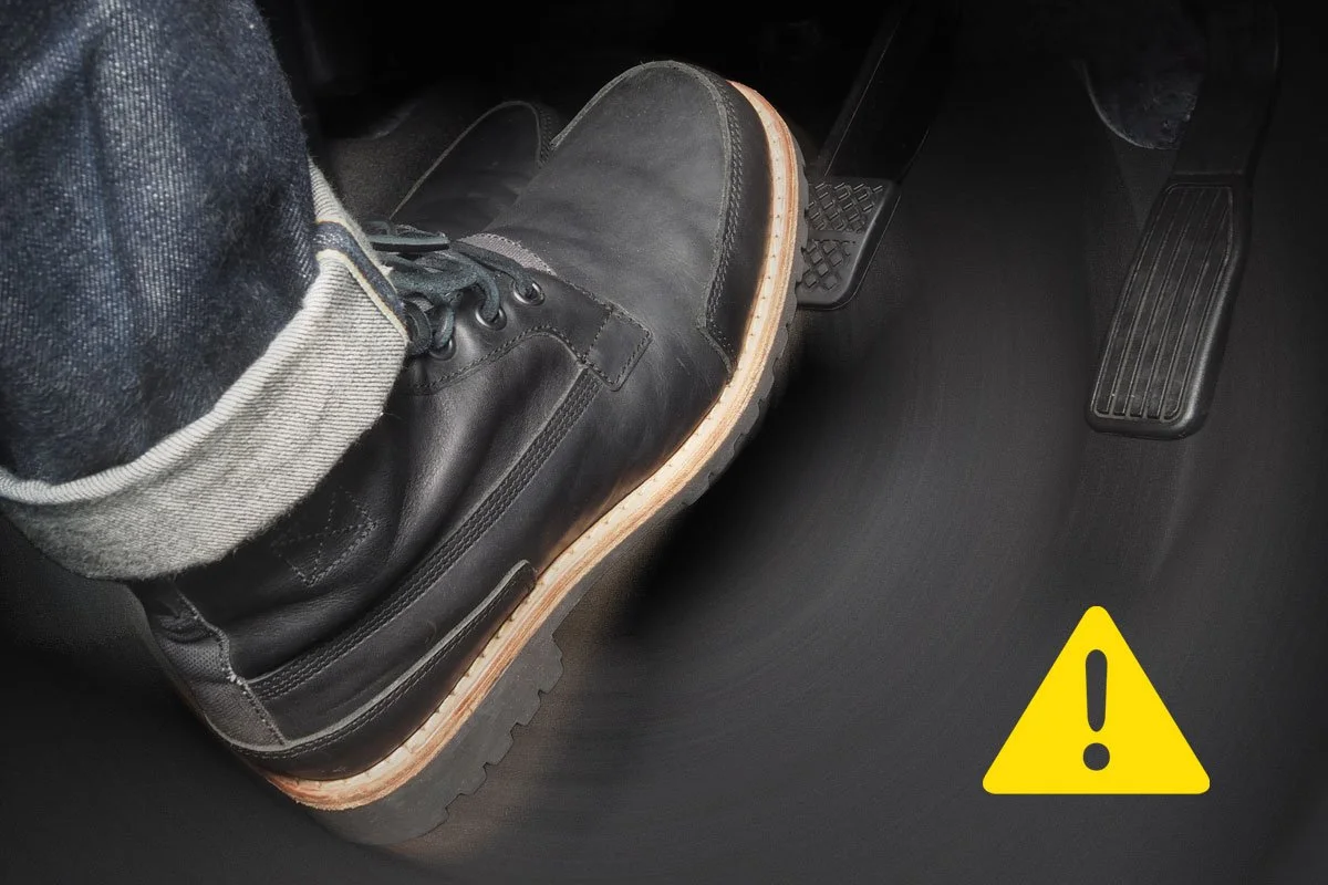 Foot stepping on brake pedal