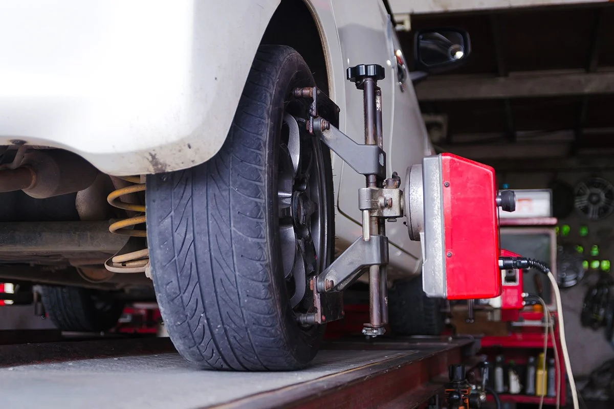 Wheel alignment machine attached to the wheel of a white vehicle