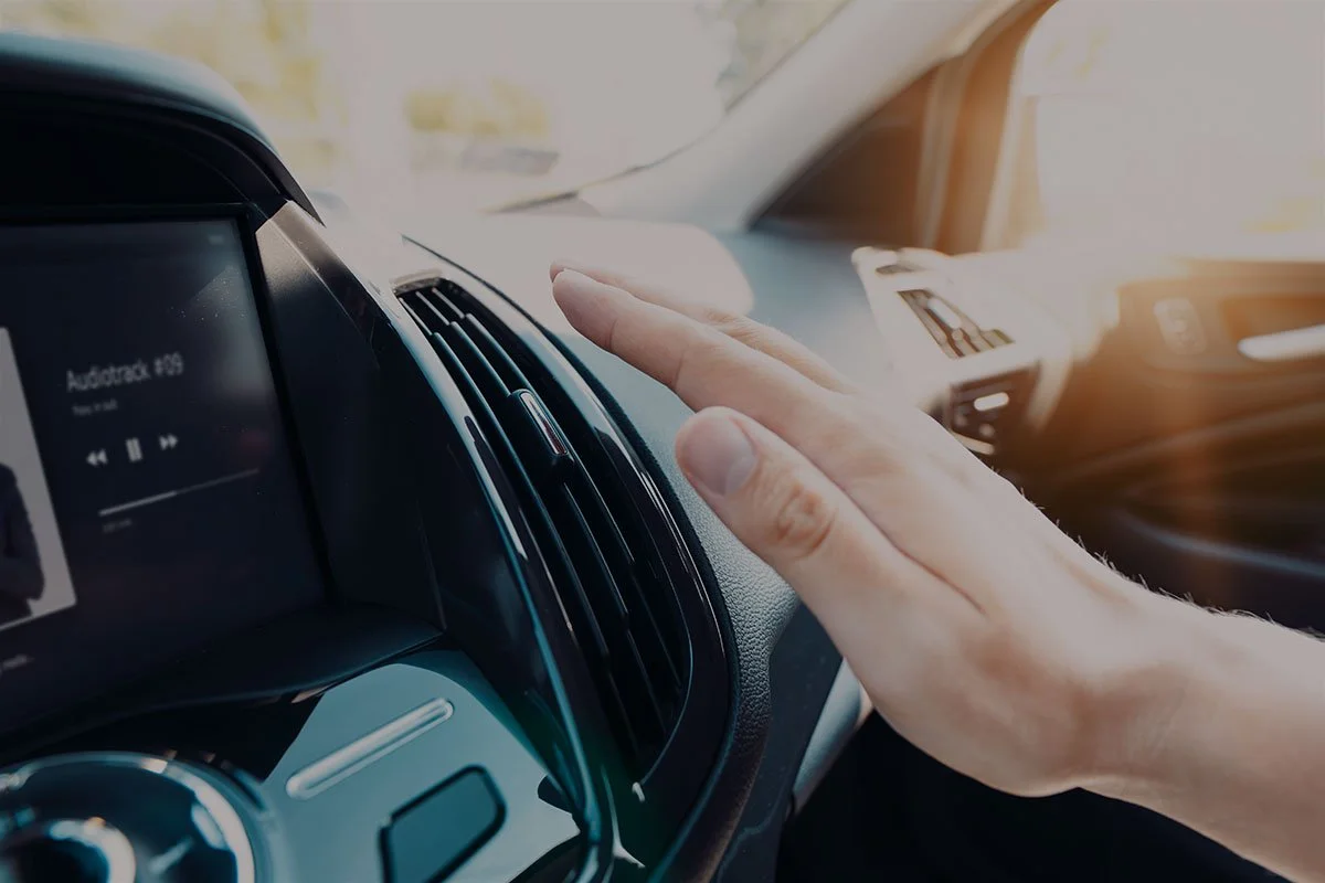 hand checking air vent in car interior