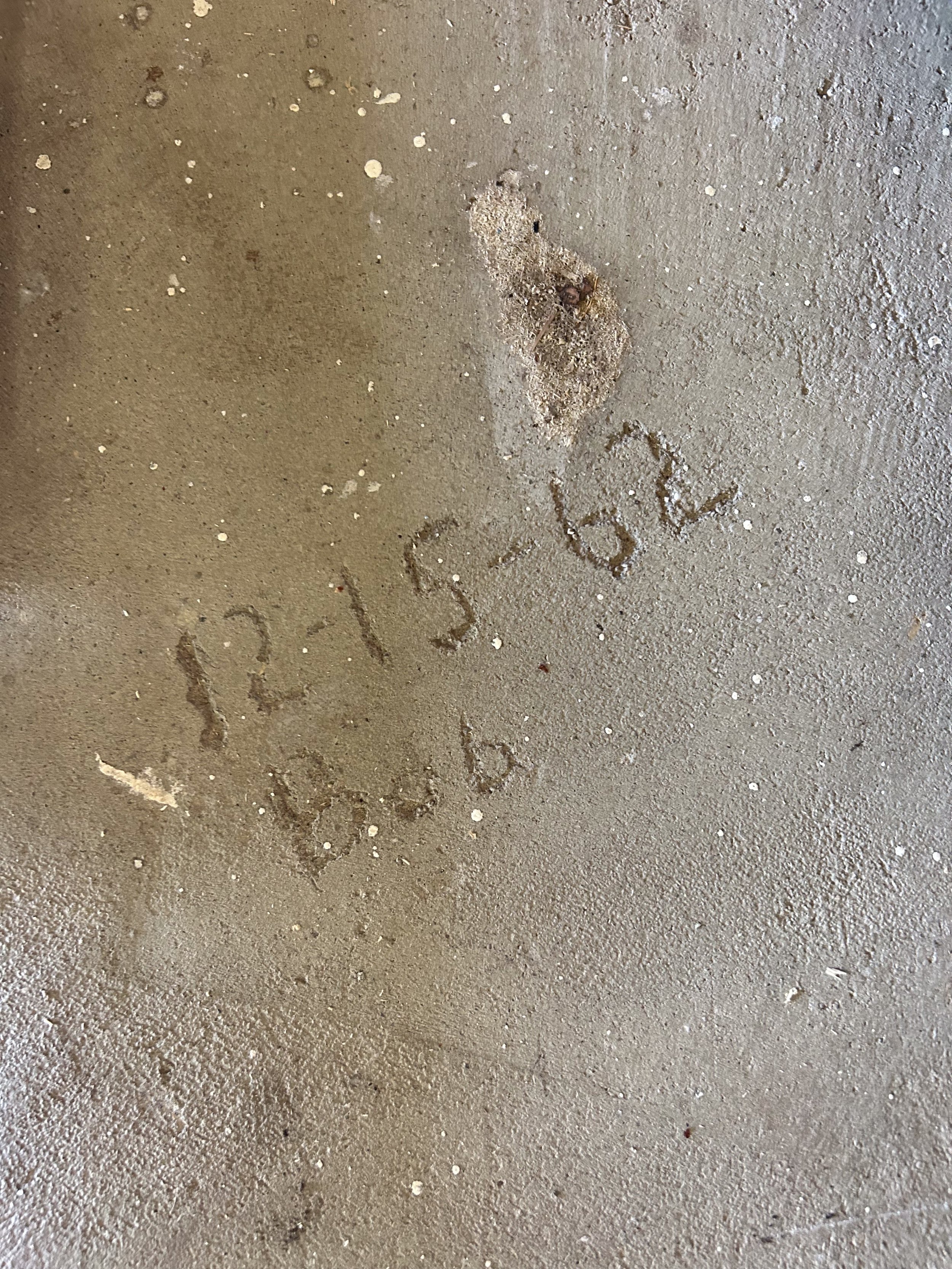 Concrete with the date 12-15-62 and "Bob" scratched in to it.