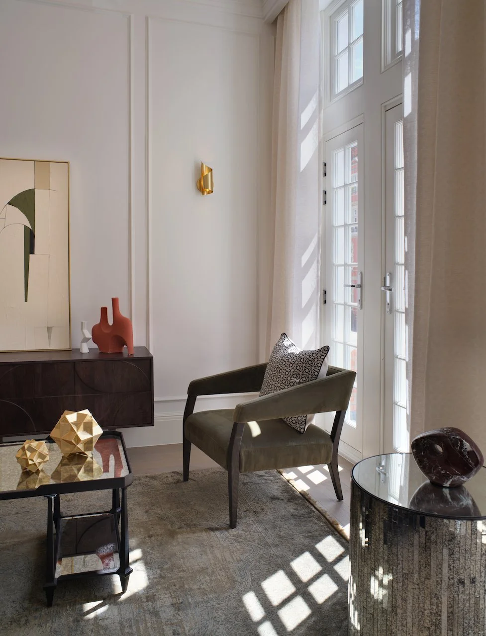 Living room with a window, armchair, coffee table, and decorative objects.