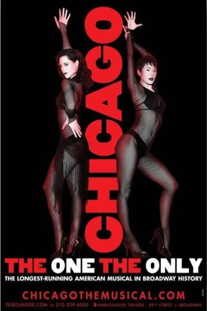 Poster for the musical "Chicago," featuring two women in fishnet stockings and high heels, standing on either side of the word "Chicago" written vertically in red letters. The tagline says, "The one the only," with additional text about the musical's history and website.