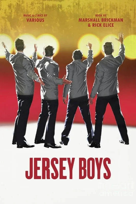 Poster of the musical Jersey Boys featuring five men in suits with their backs turned, raising their hands against a background of bright yellow lights and a red gradient.