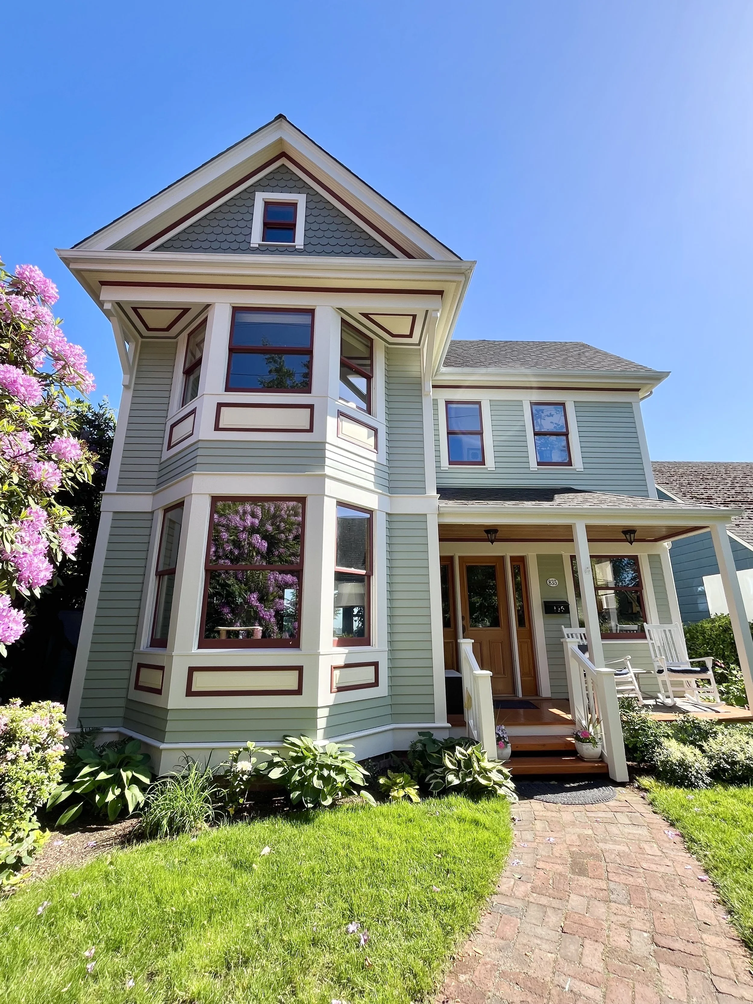 colorful victorian home painted shades of green, yellow, cream, and maroon
