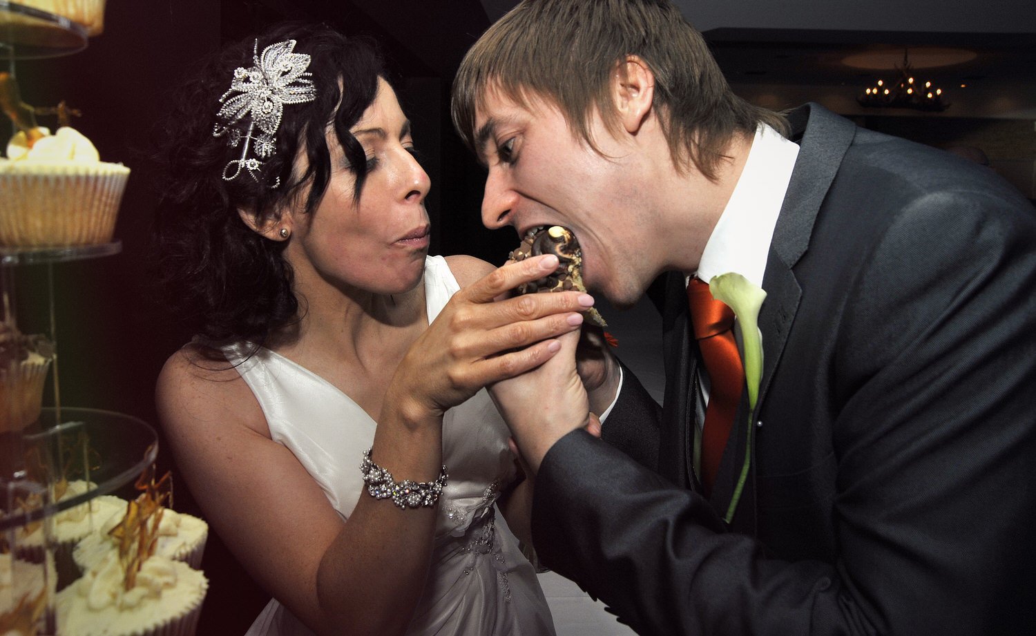 Bride and groom share a bite of wedding cake.