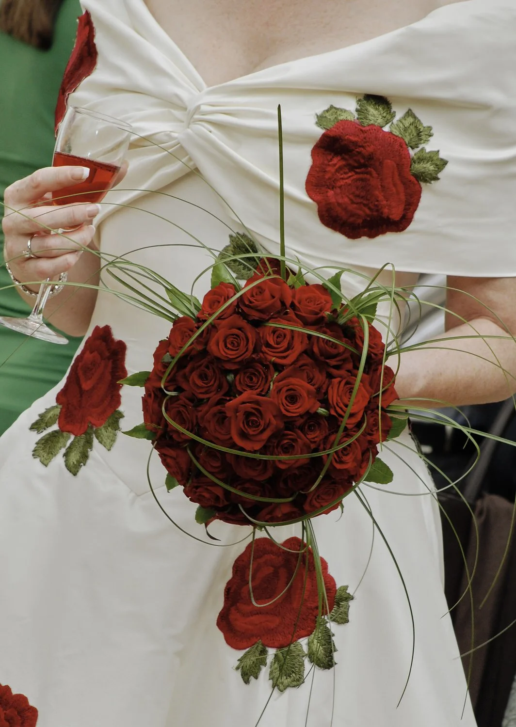 Close-up of bridal bouquet with small red roses.
