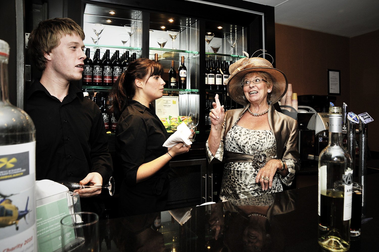 Mother of the bride behind the bar cheekily talking to bar staff.