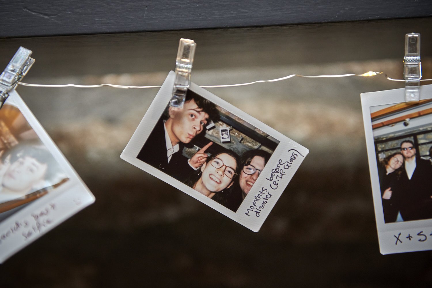 A detail shot of guests' polaroid pictures hung on a line at the reception.