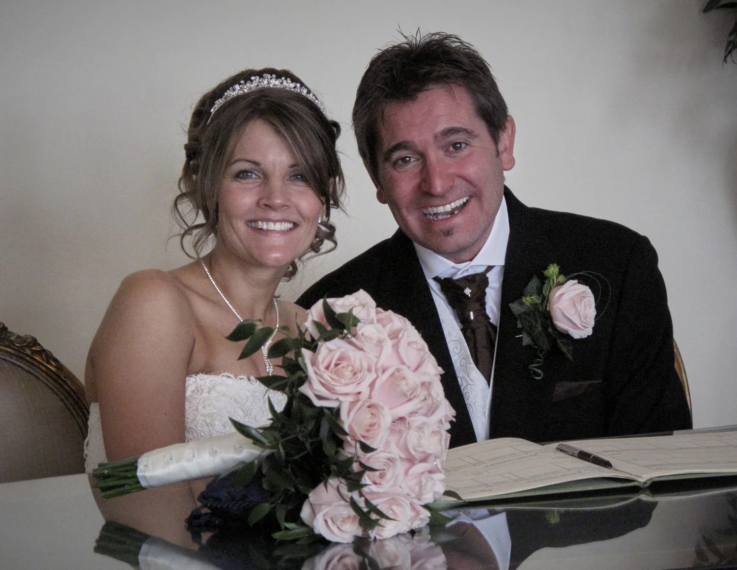 Bride and groom pose while signing the register.