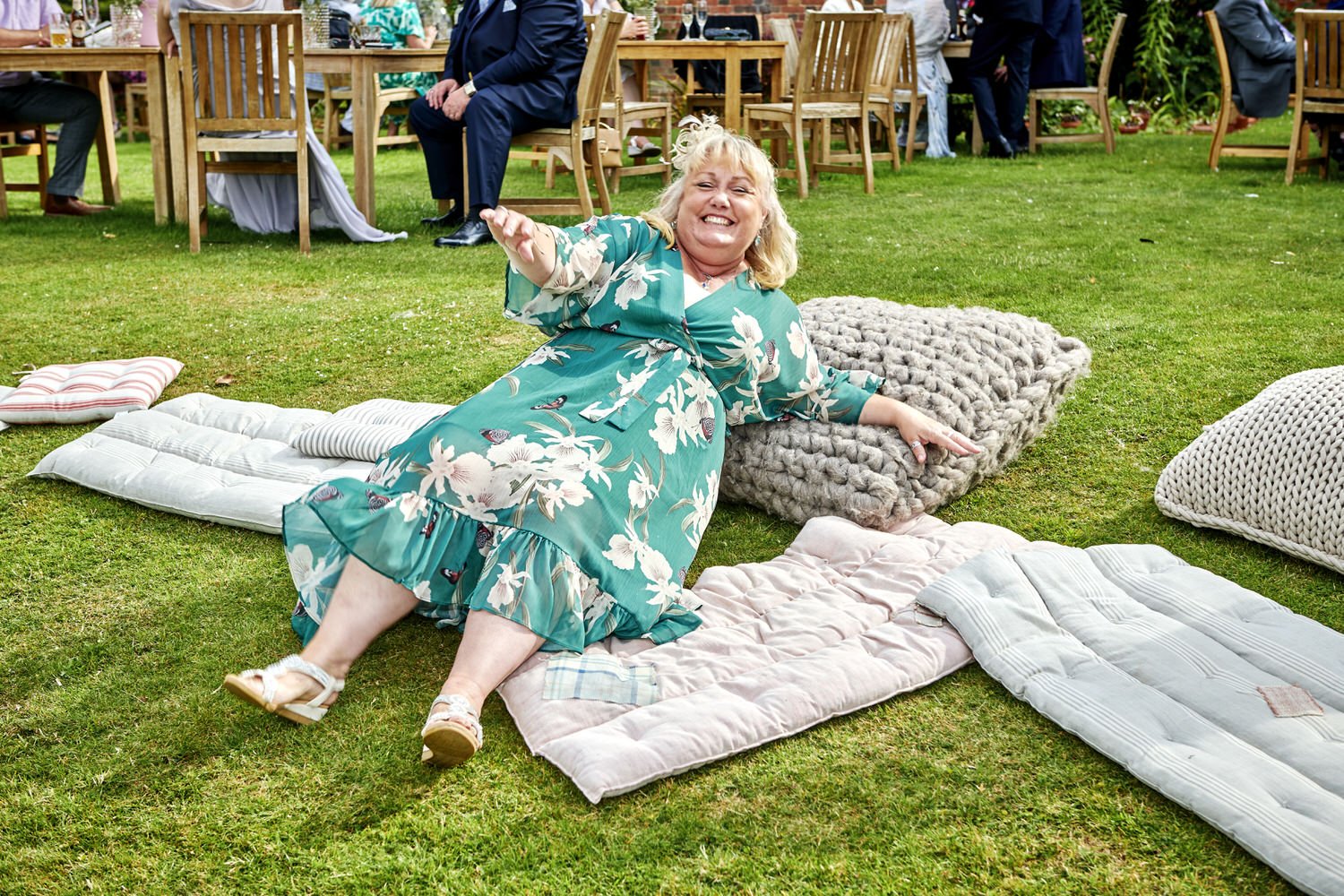 Guest lying on cushions in a green pretends to struggle to get up.