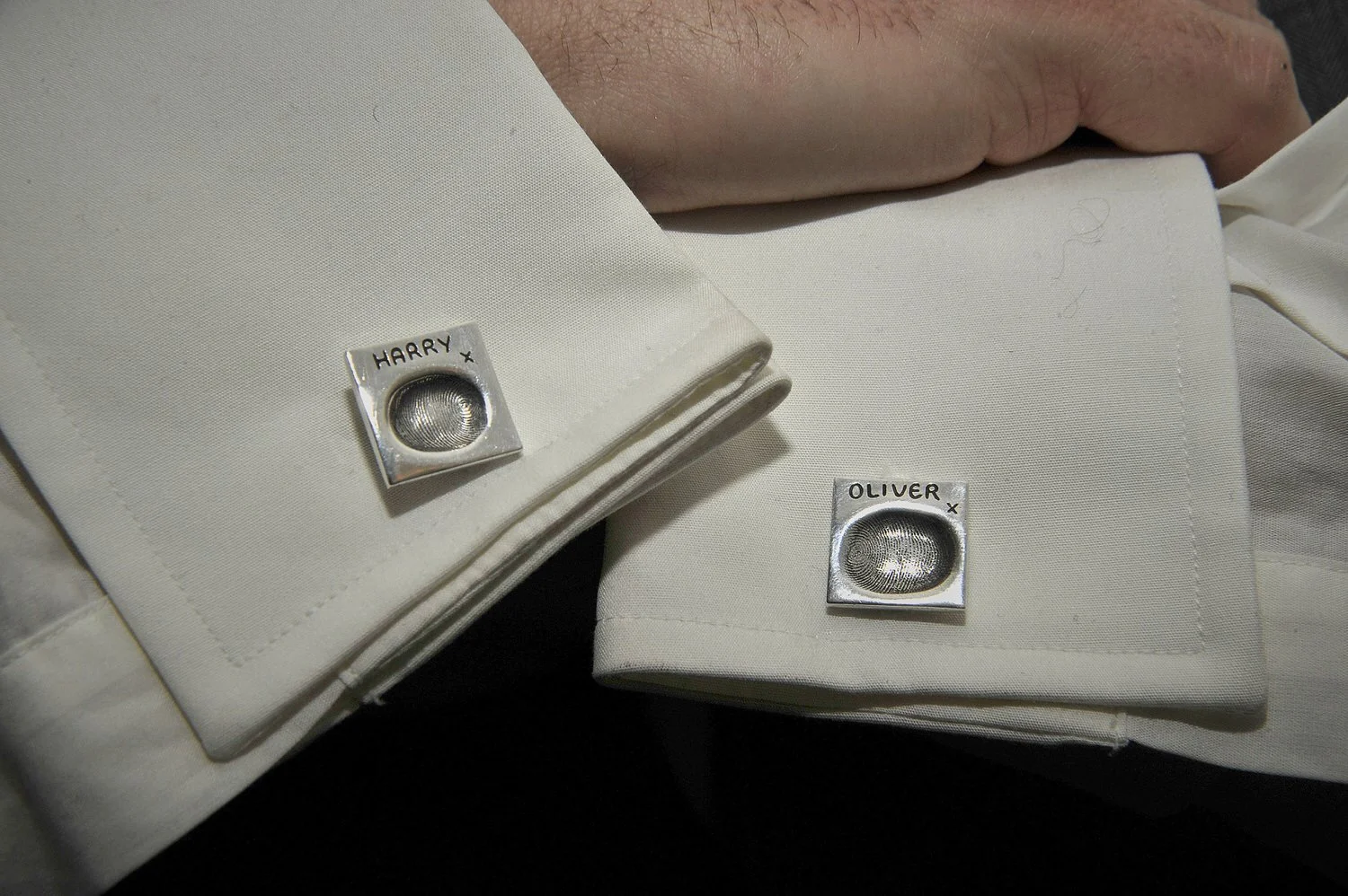 Close-up shot of groomsmen's matching custom cufflinks.