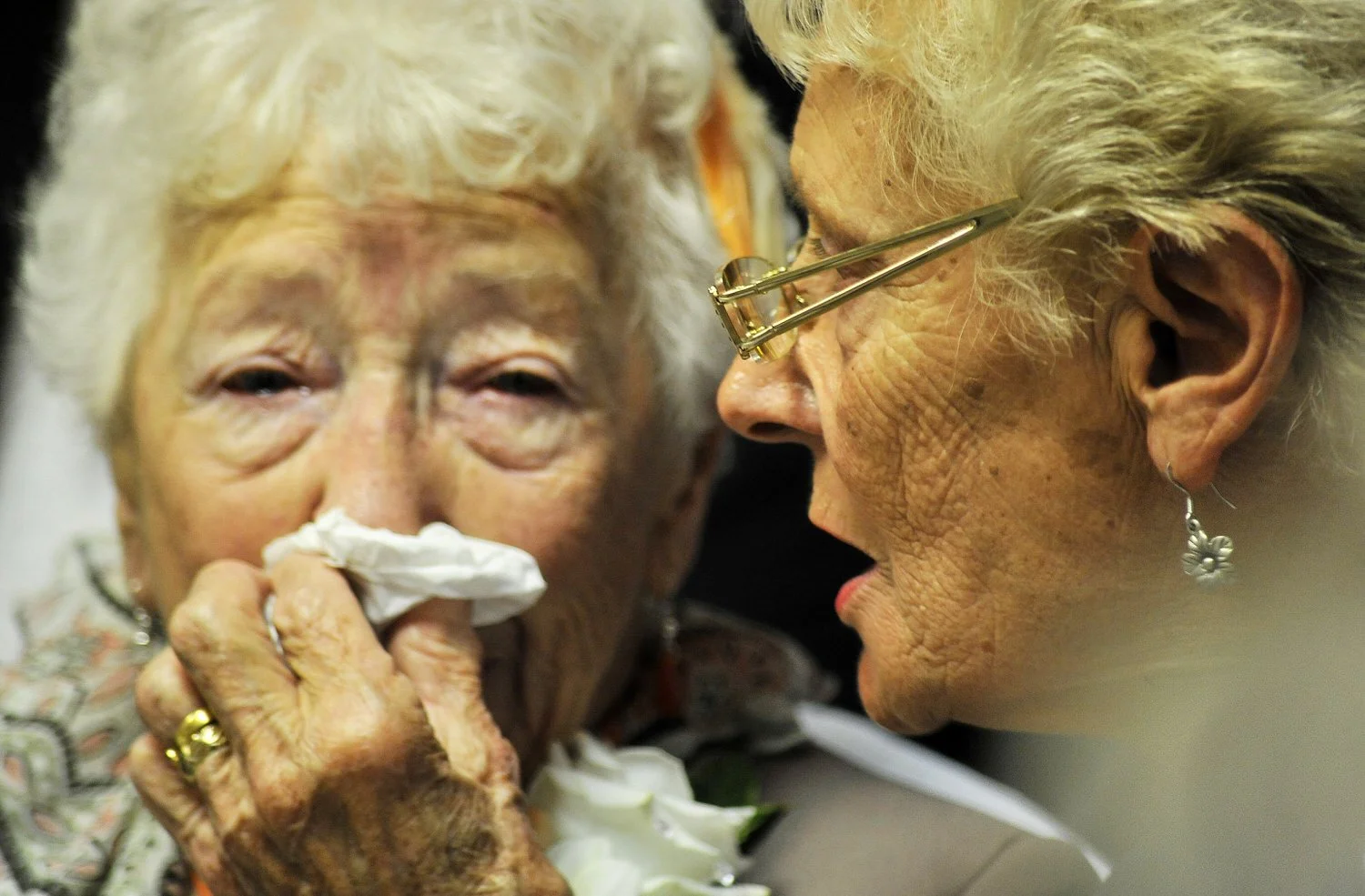 Elderly lady holds handkerchief to her nose as she becomes emotional.