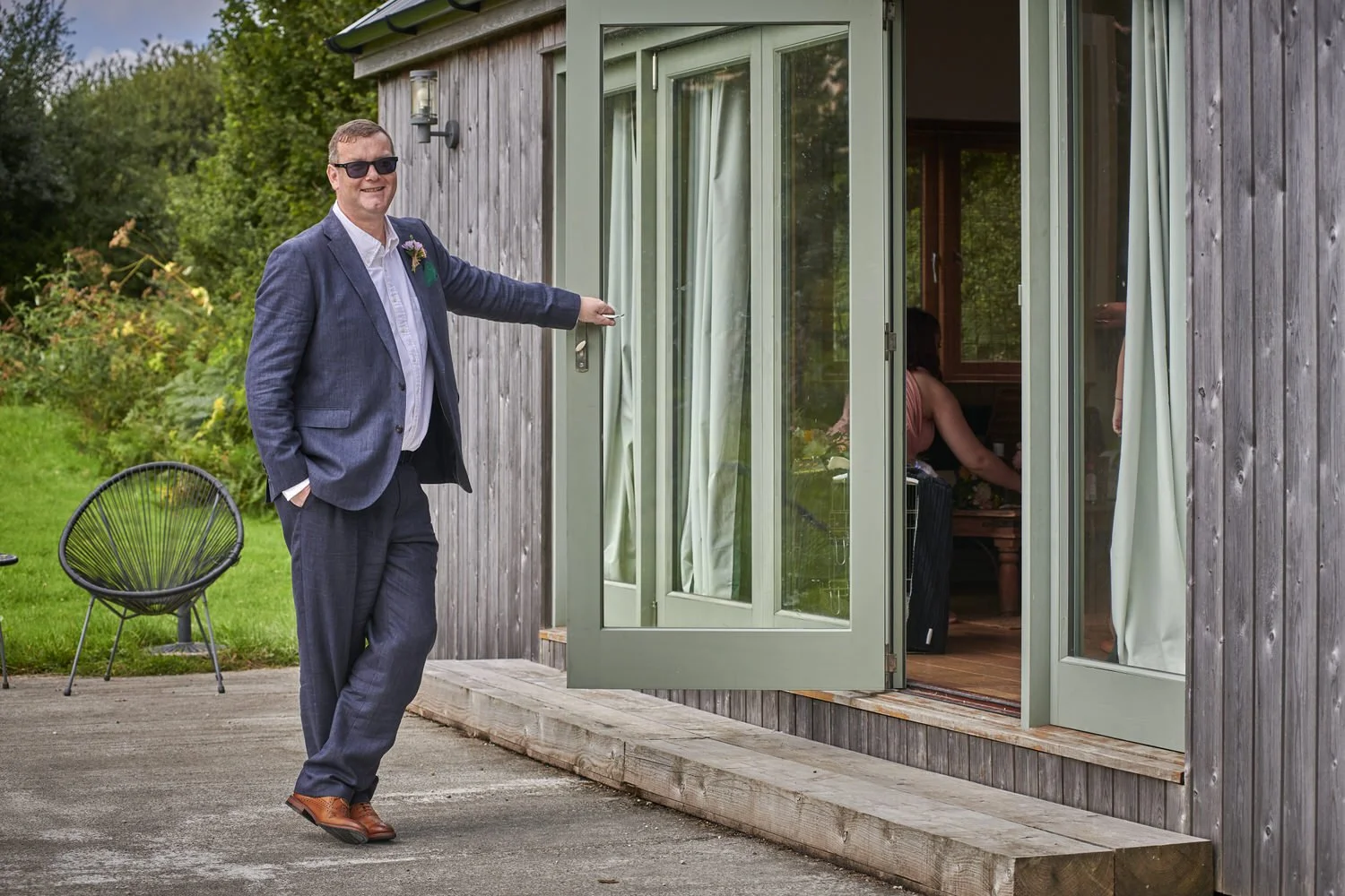 Father of the bride stands proudly outside looking in on his daughter.
