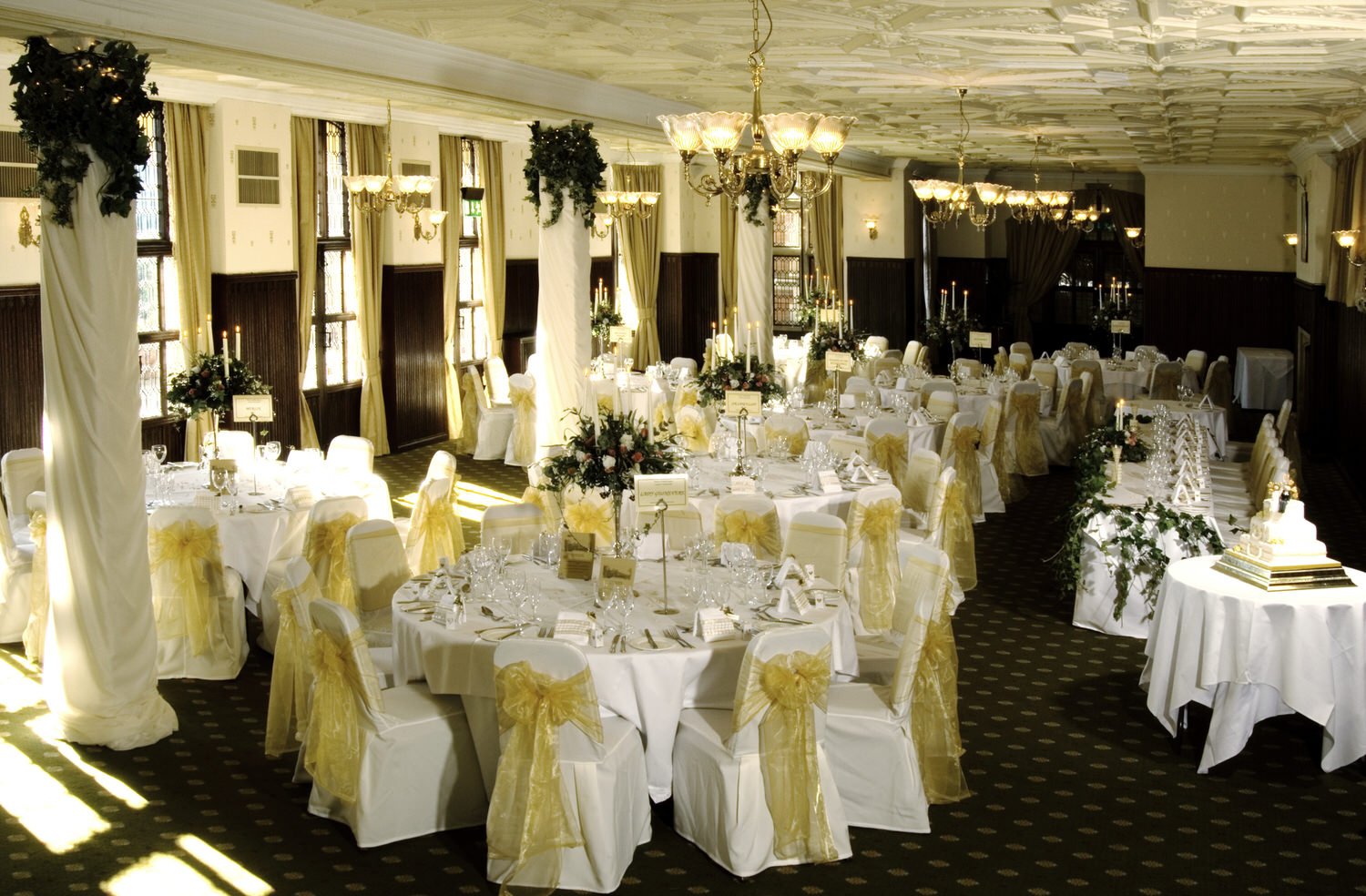 Large beautifully arranged wedding reception room, tables set with glasses.