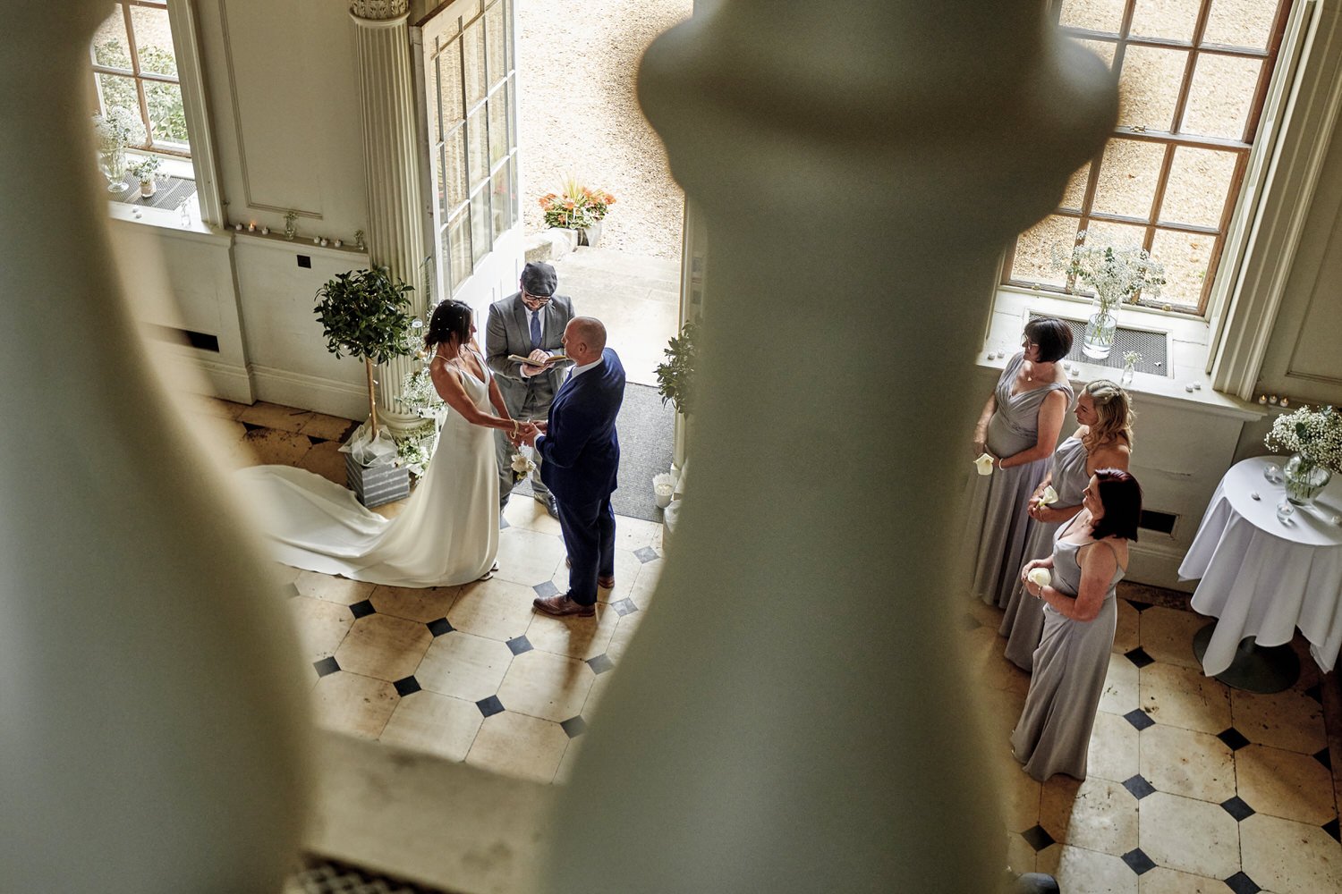 View of wedding ceremony from high balcony looking at bride and groom taking their vows.
