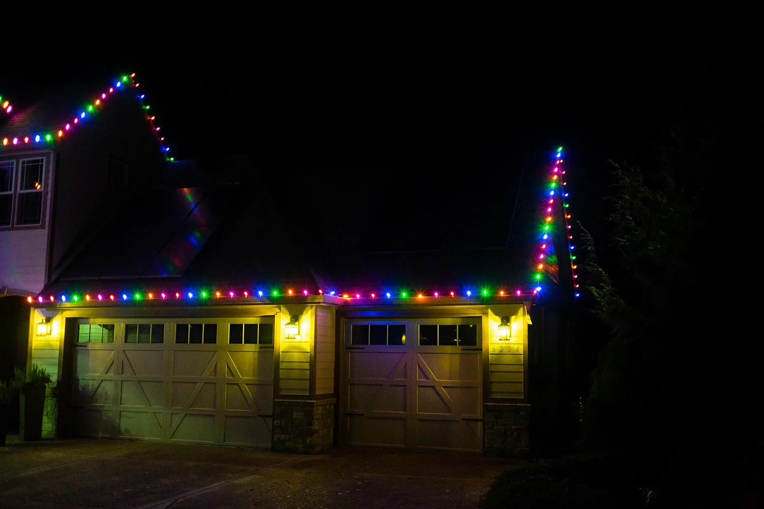 Multicolor C9 lights framing a two-car garage and roof peak