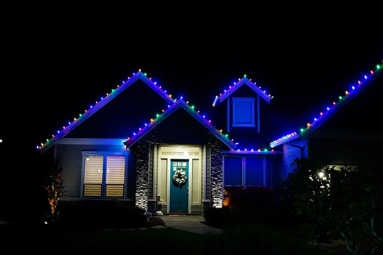 Blue and teal C9 lights outlining a home's rooflines