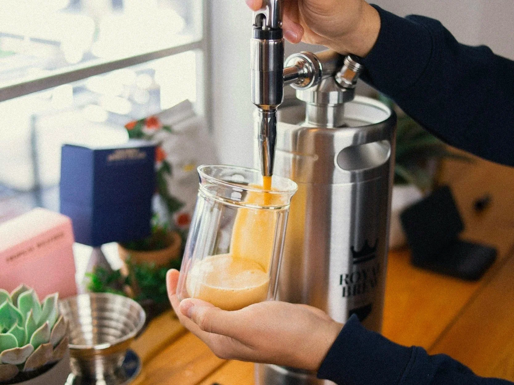 copo de vidro sendo enchido com Nitro Cold Brew, mostrando efeito cascata e espuma cremosa