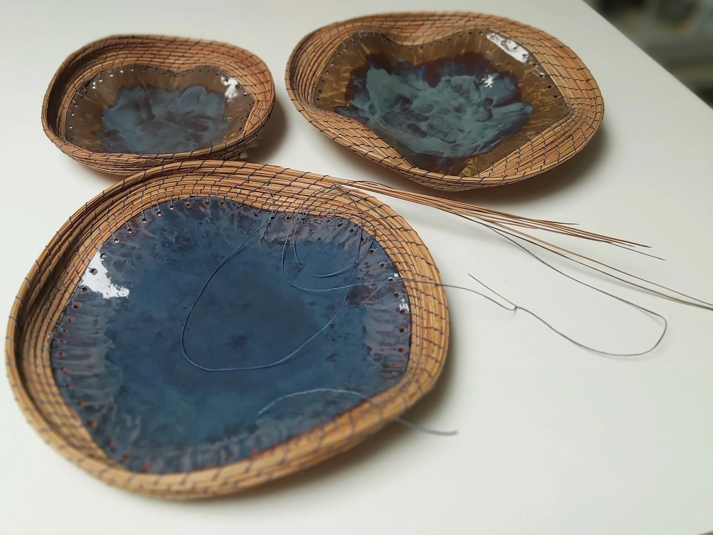 Wavy terracotta bases with pine needles.