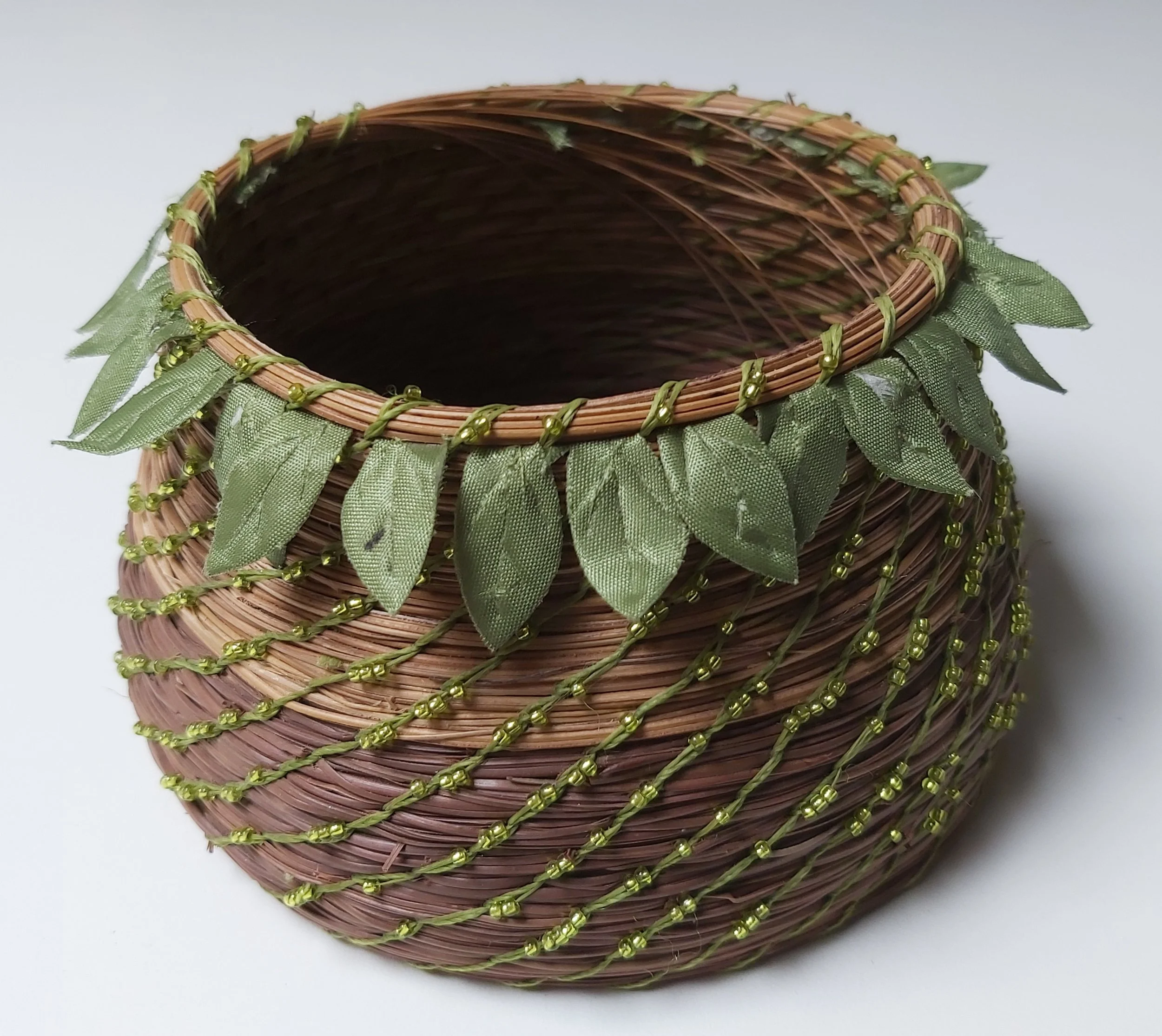 Fijian basket, the lighter rows are coiled with the softer fibres of  the sasa brooms  people use there. They are handmade from the coconut leaf spines.