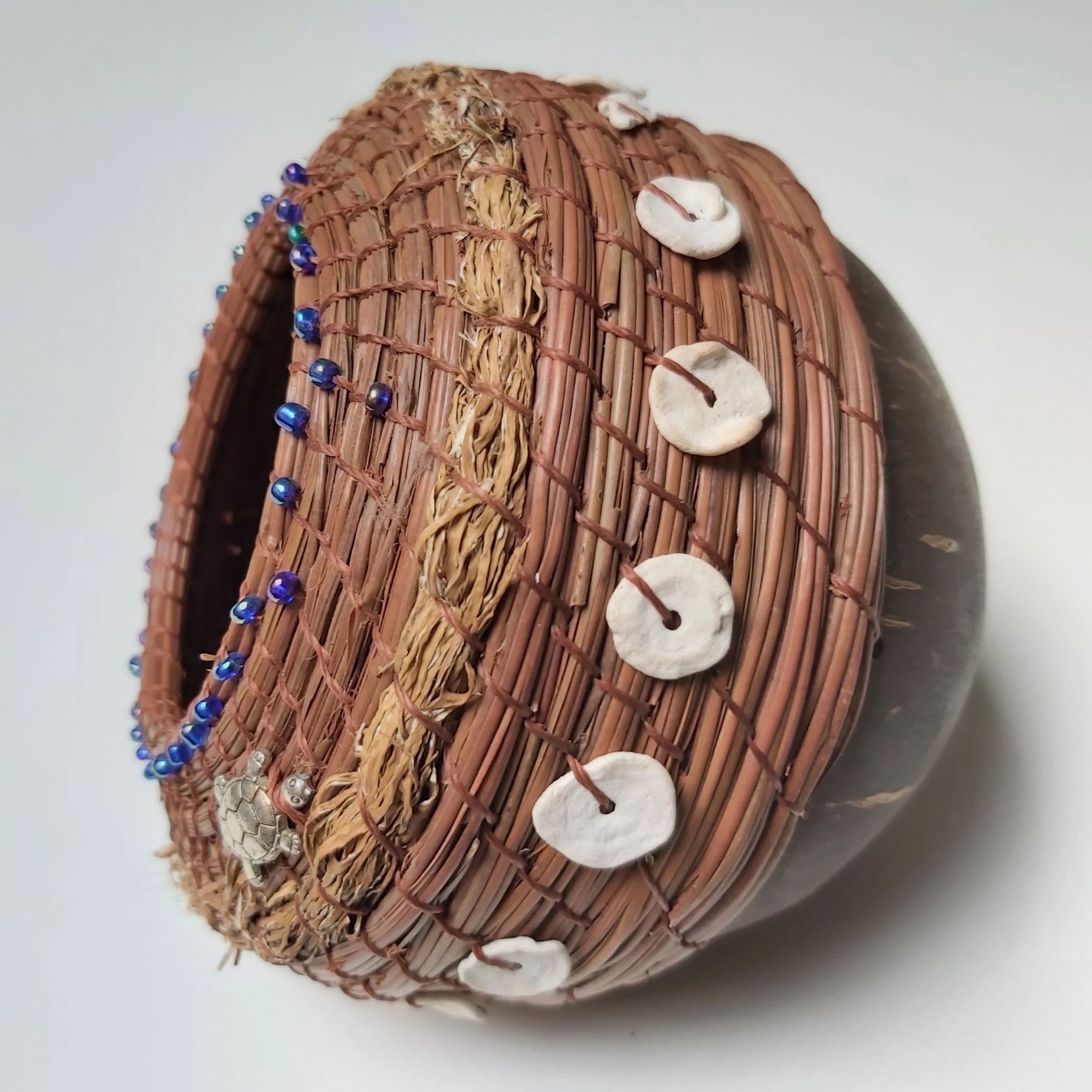 Fijian coconut husk with found shells  and seaweed on seaside at low tide.