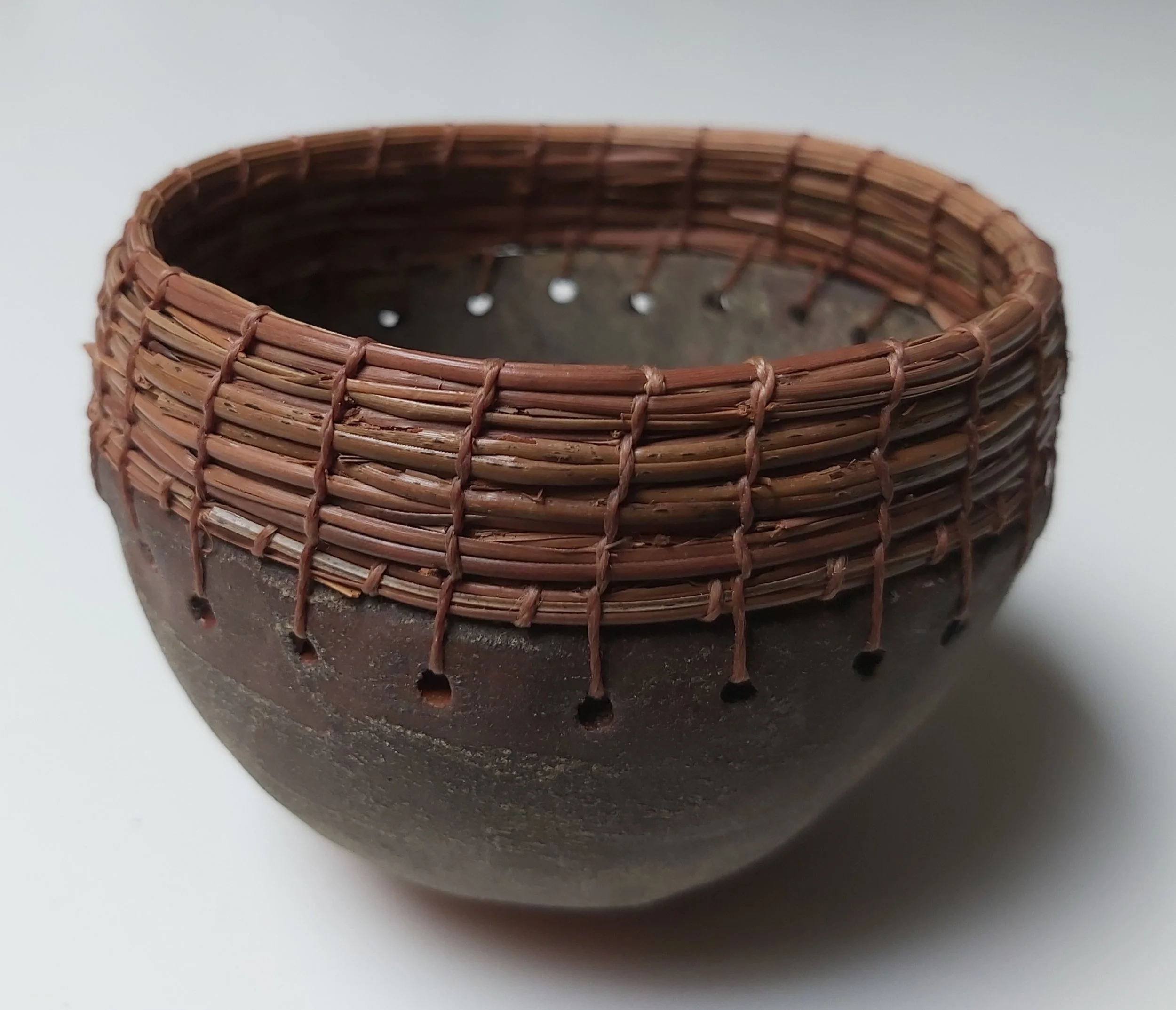 Pinched pot with pine needles.