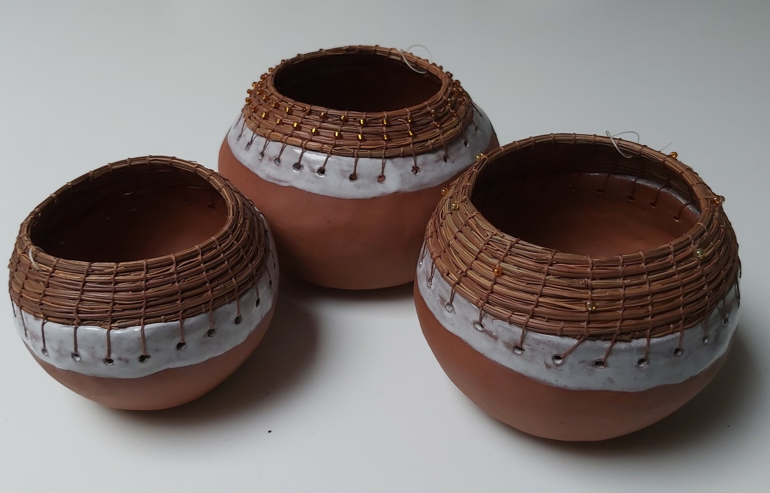 Three little pots, 'pods'. Terracotta with pine needles.