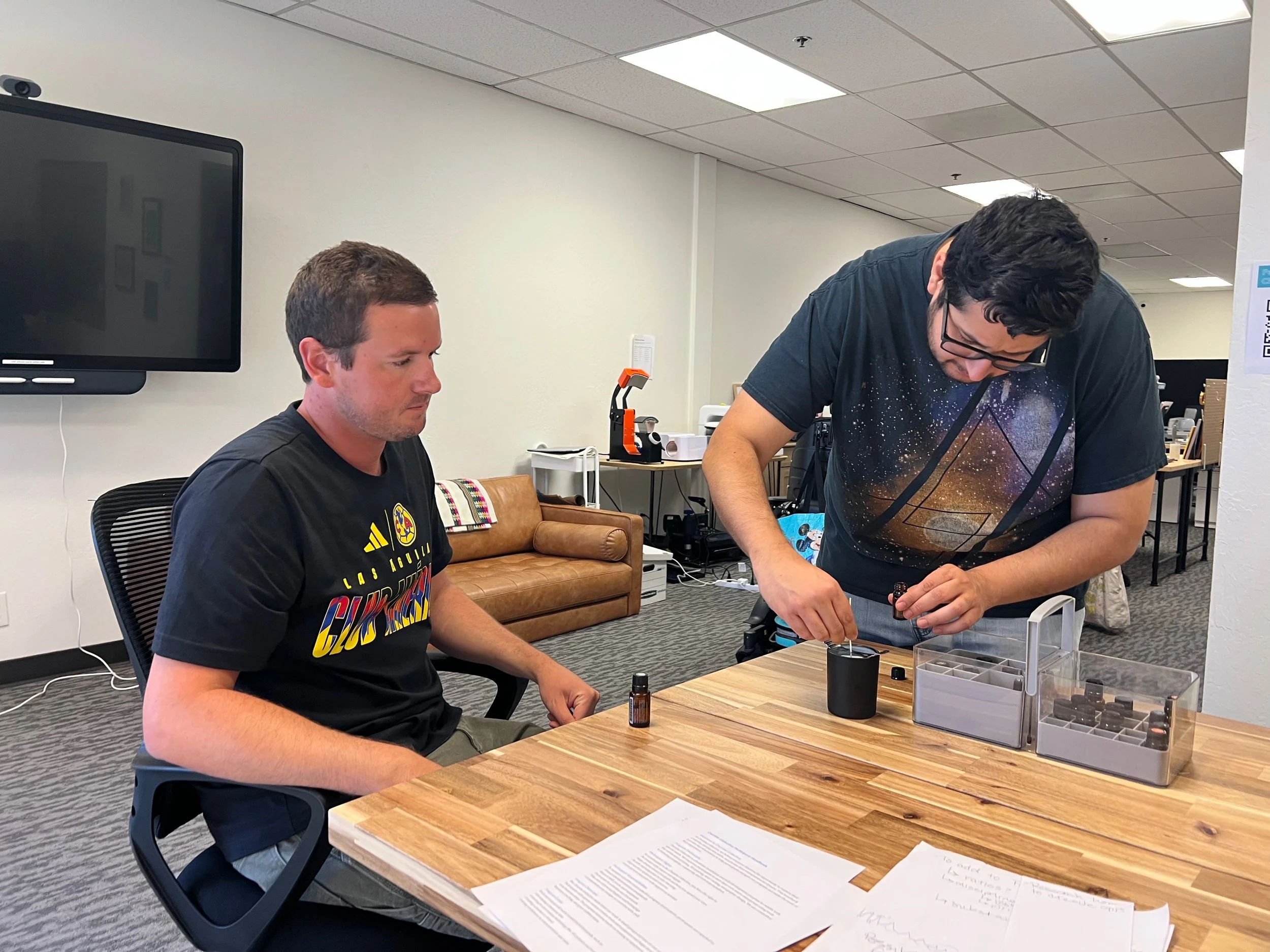 Staff Member overlooking Participant learning to make a Candle