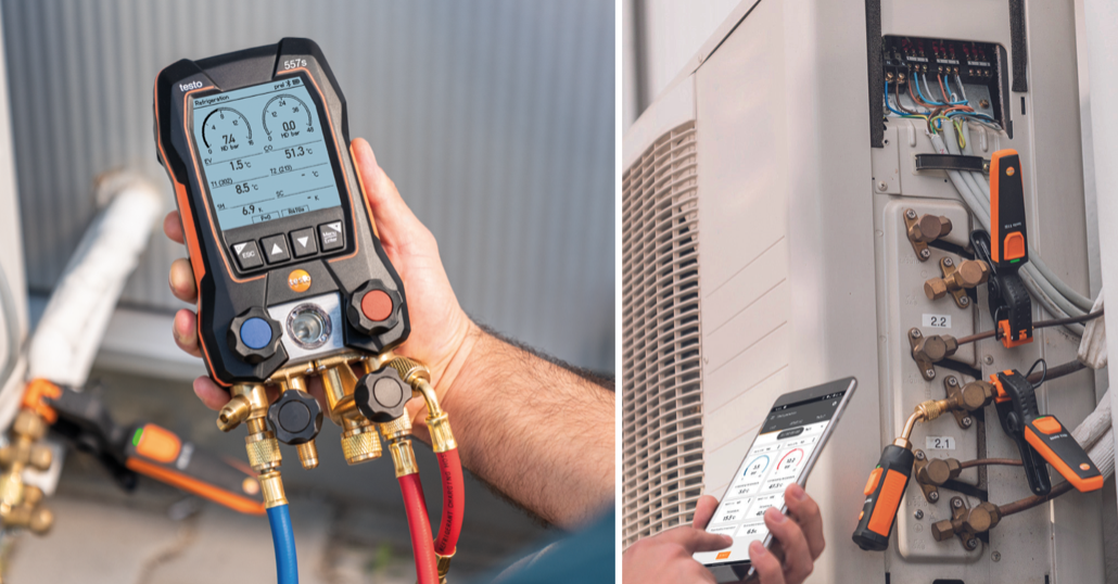 Un technicien qui tient un appareil de mesure, probablement un thermomètre ou un multimètre, devant un HVAC, avec un autre technicien contrôlant un système de climatisation ou de chauffage à l'aide d'une application mobile.