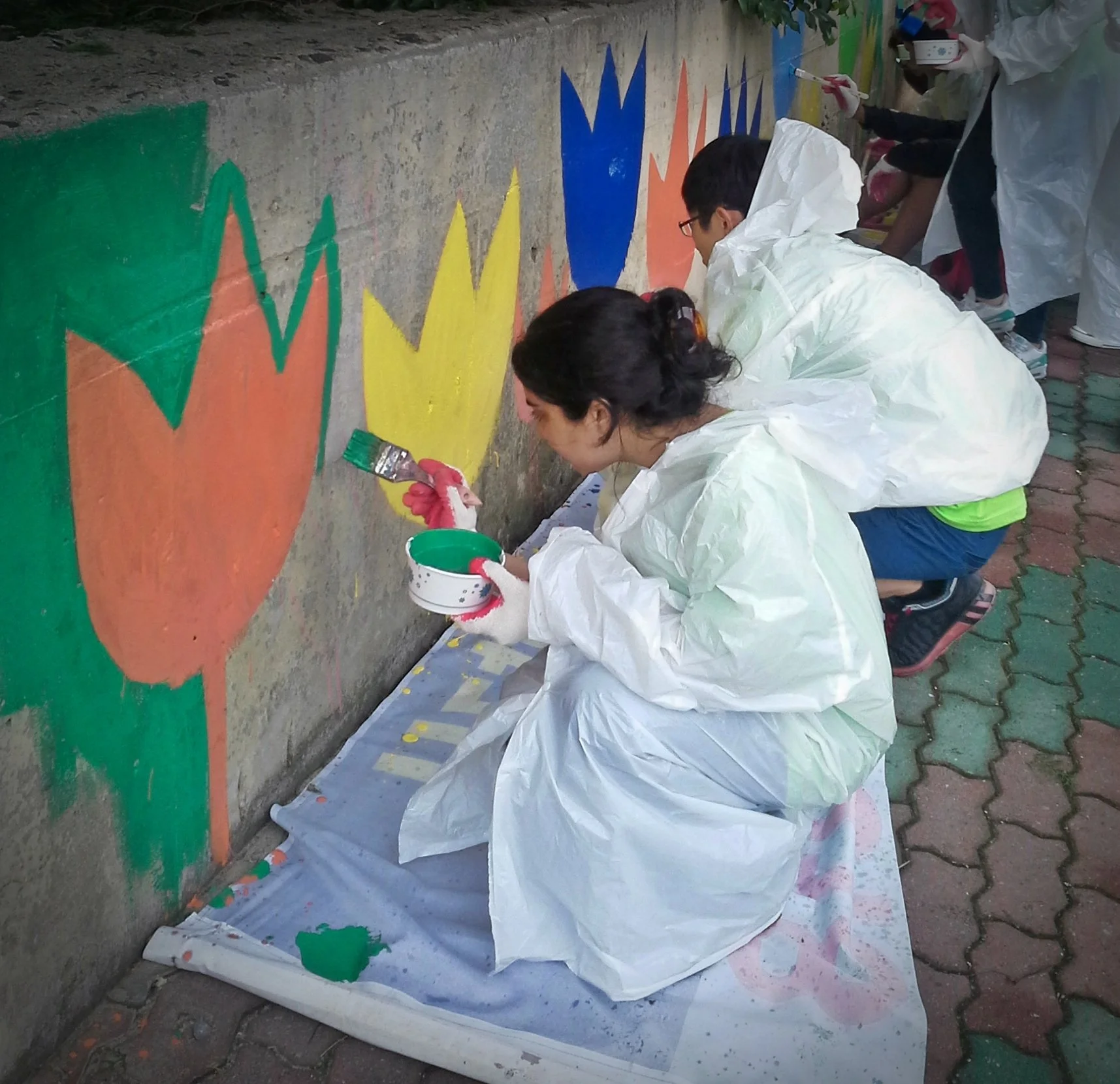 Delegates paint a mural as part of a community service project during the Korea-America Student Conference, showcasing cultural connection through art.