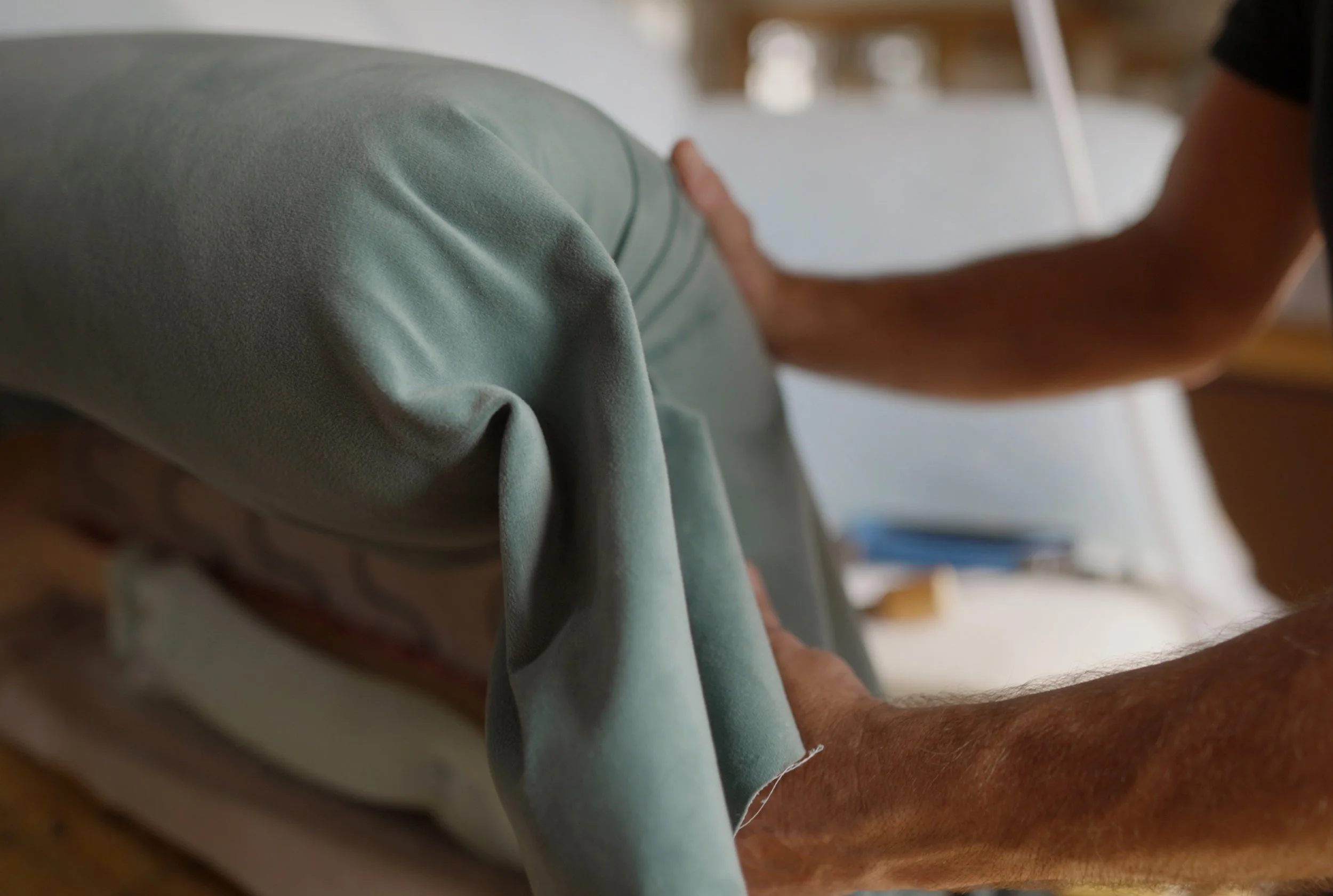 A person providing physical therapy to a patient lying on a treatment table, focusing on the patient's shoulder or arm.
