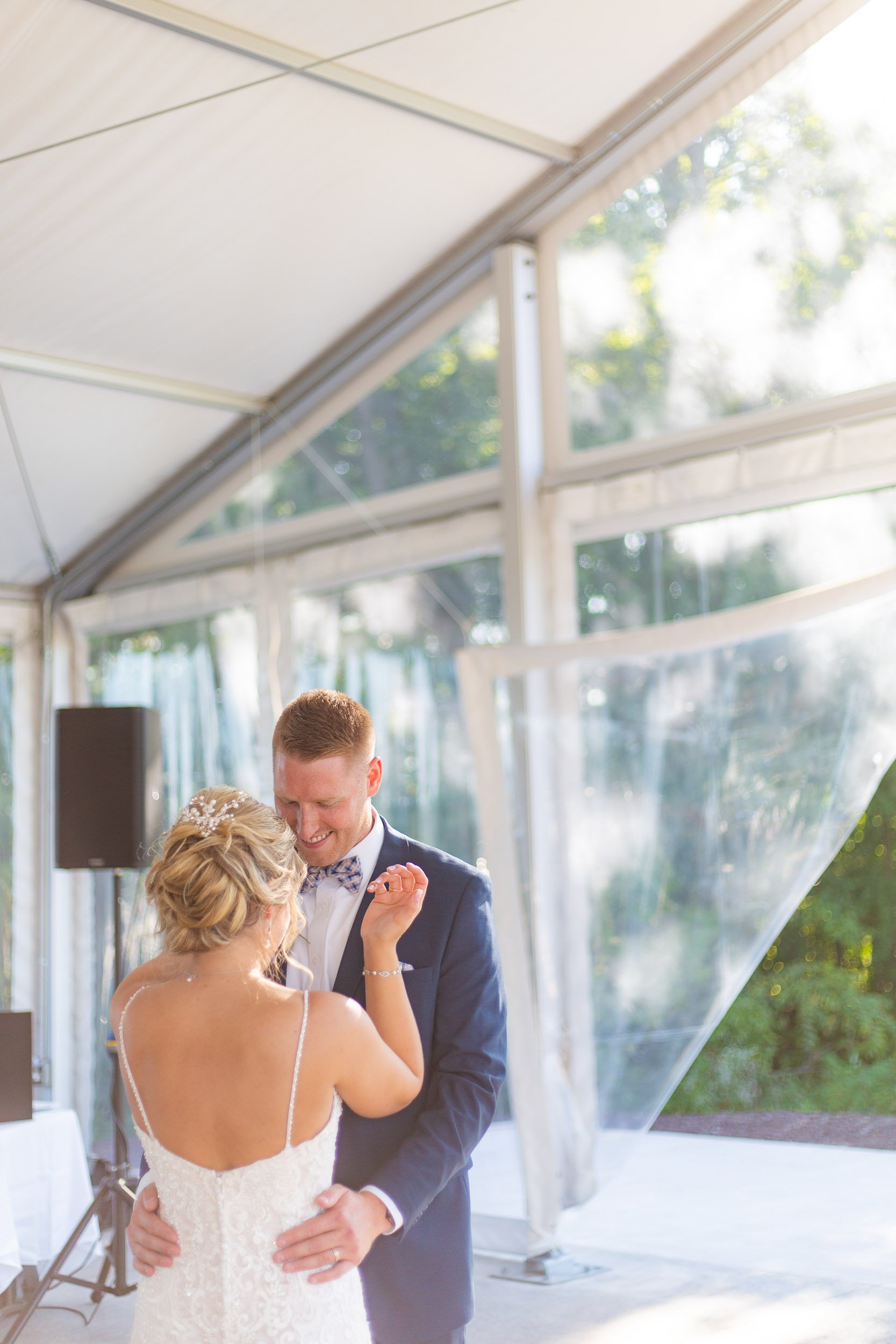 Couple sharing first dance in outdoor wedding tent