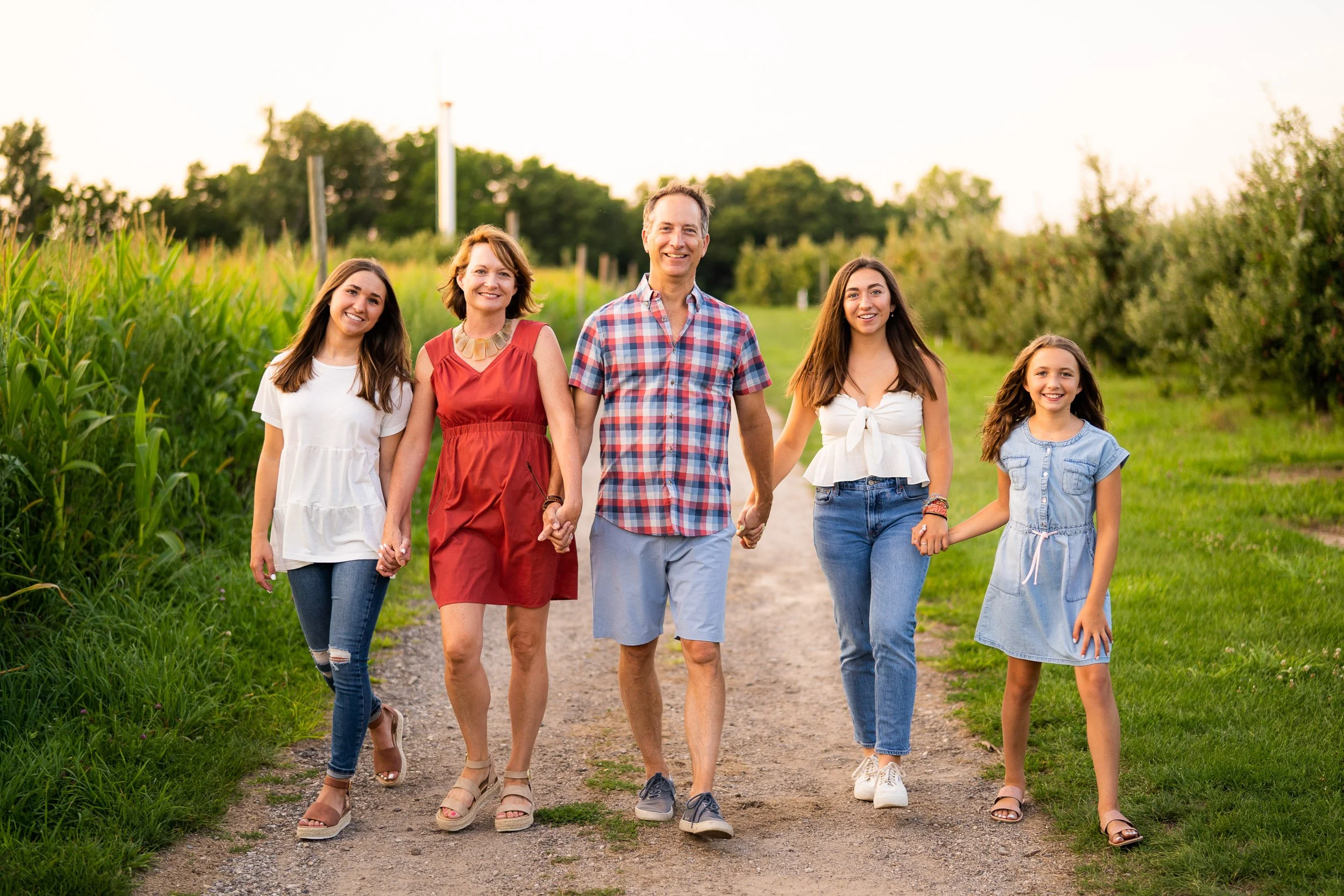 Family walking on dirt path in casual summer clothes