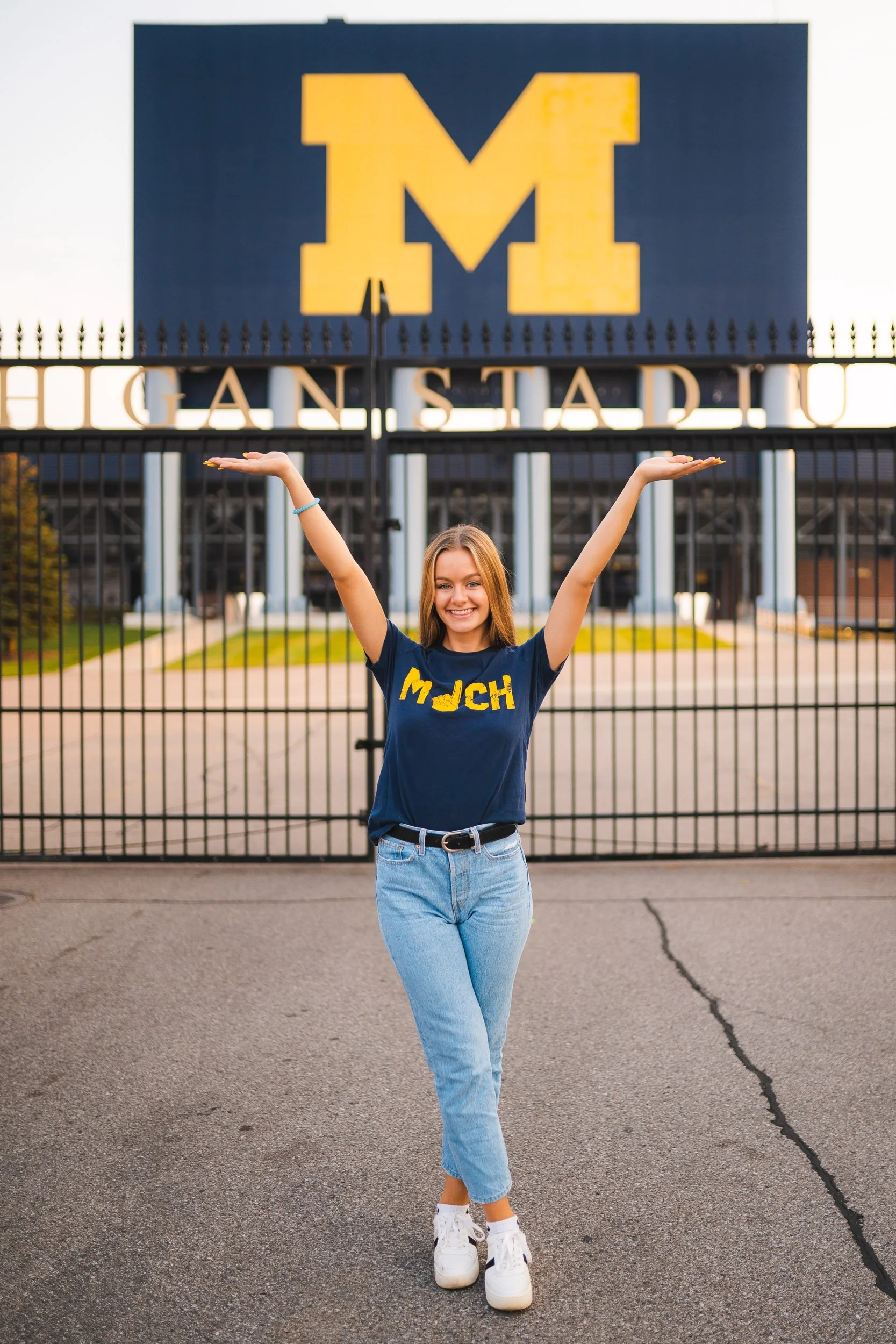 Senior girl cheering in front of University of Michigan stadium gate