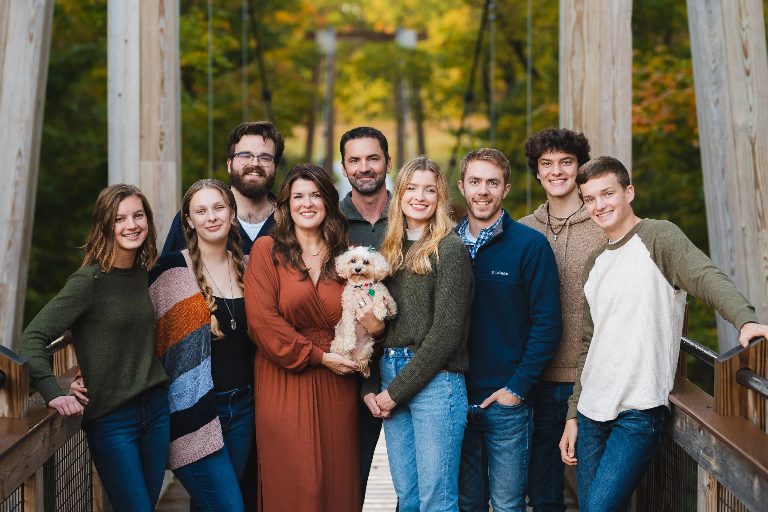 Large family group portrait with dog in autumn setting