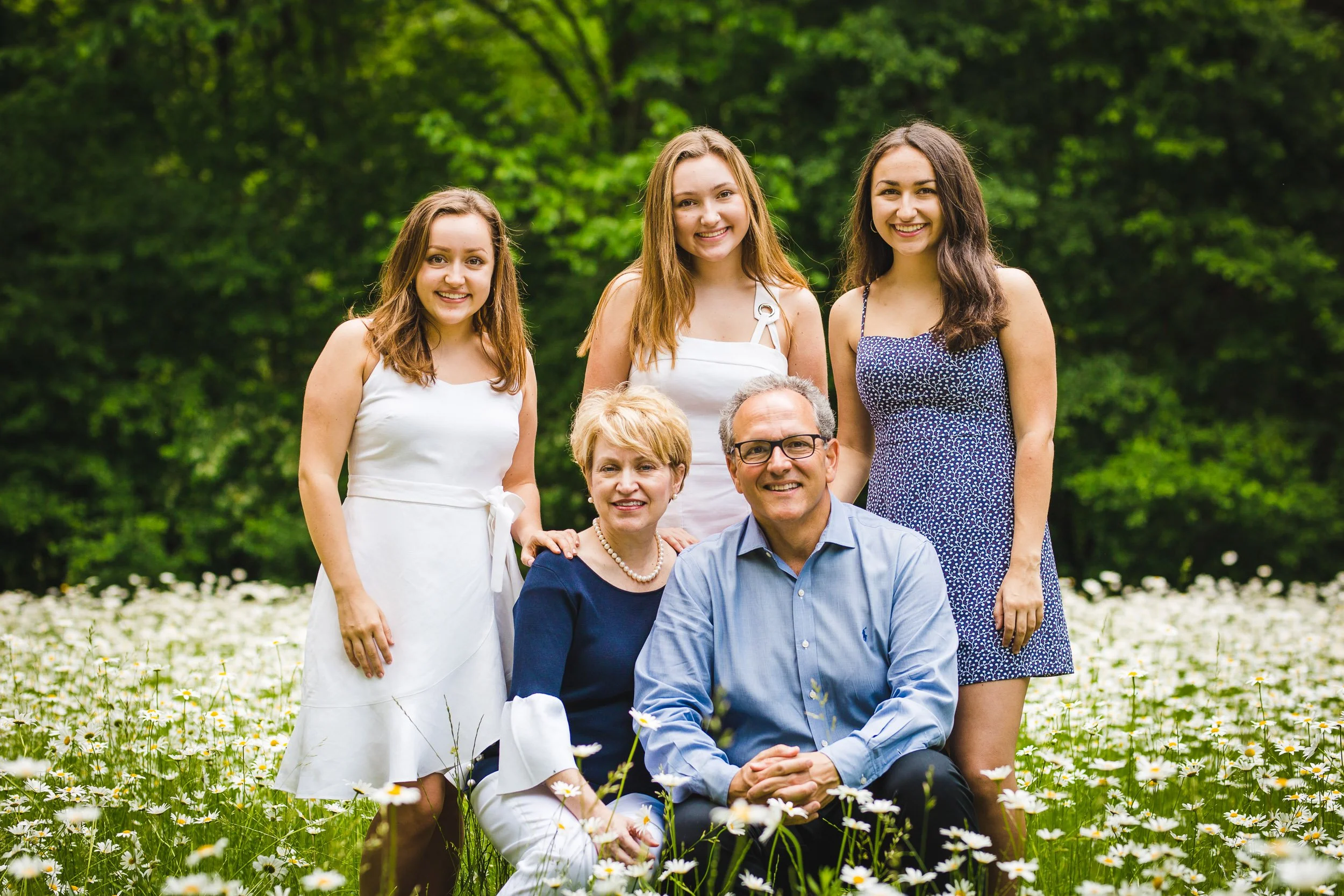 Family posing in field with wildflowers
