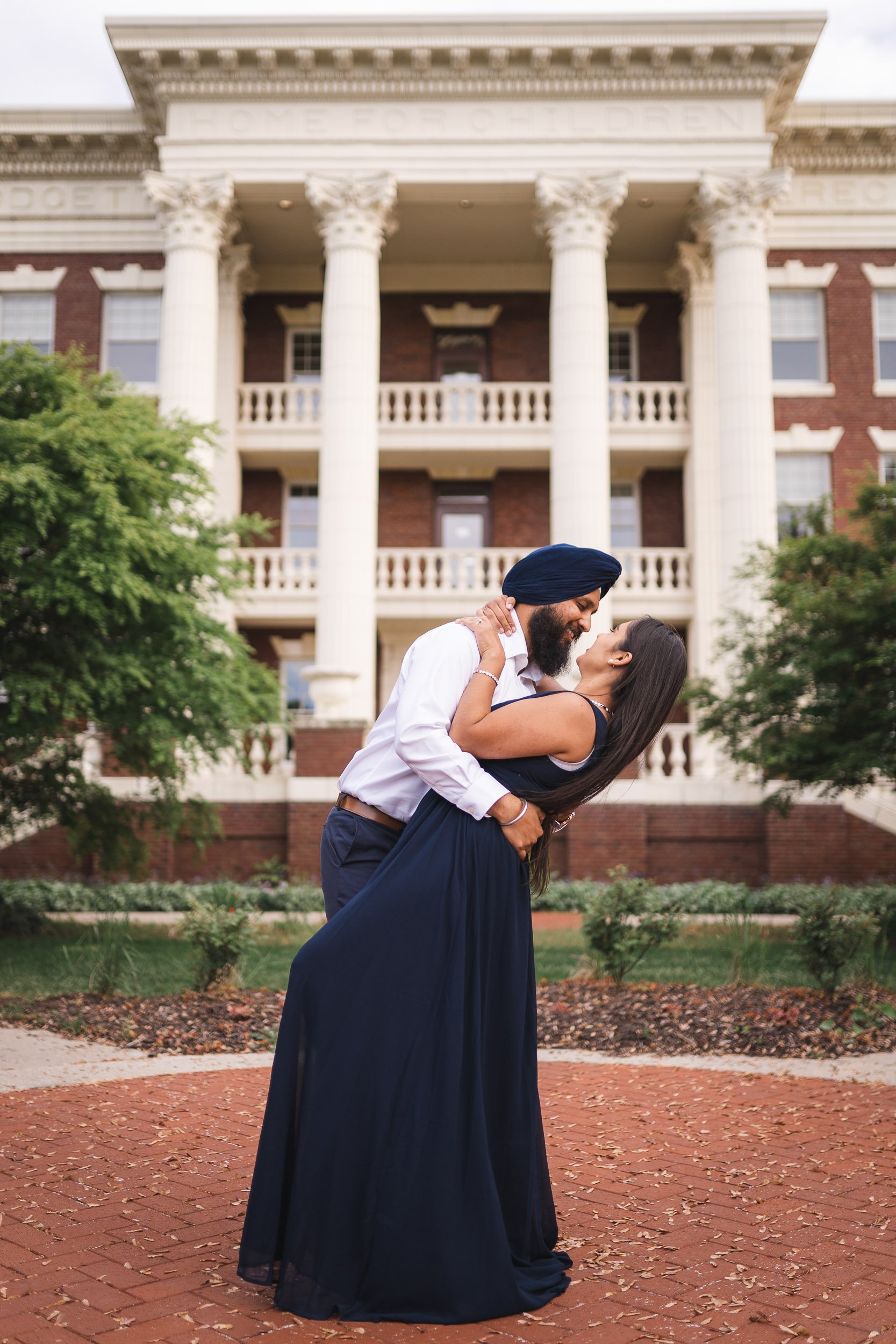 Couple kissing in front of white columns